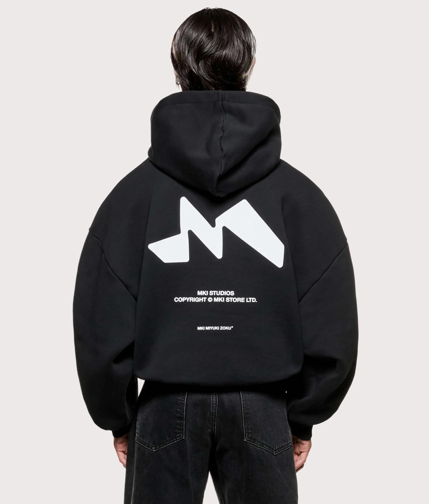 MKI MIYUKI ZOKU Silhouette Hoodie in Black at EQVVS Menswear. Model back shot.