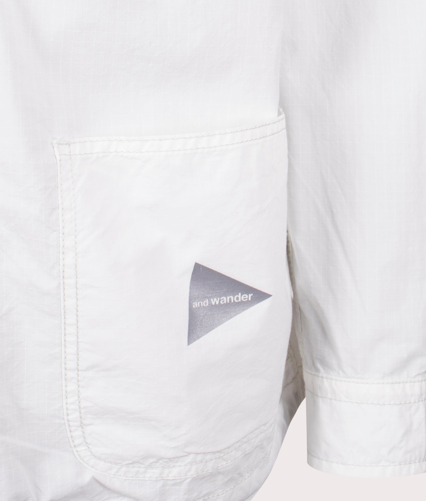 and Wander Cordura Cotton Rip Shirt Jacket in White. Shot at EQVVS. Front logo shot 