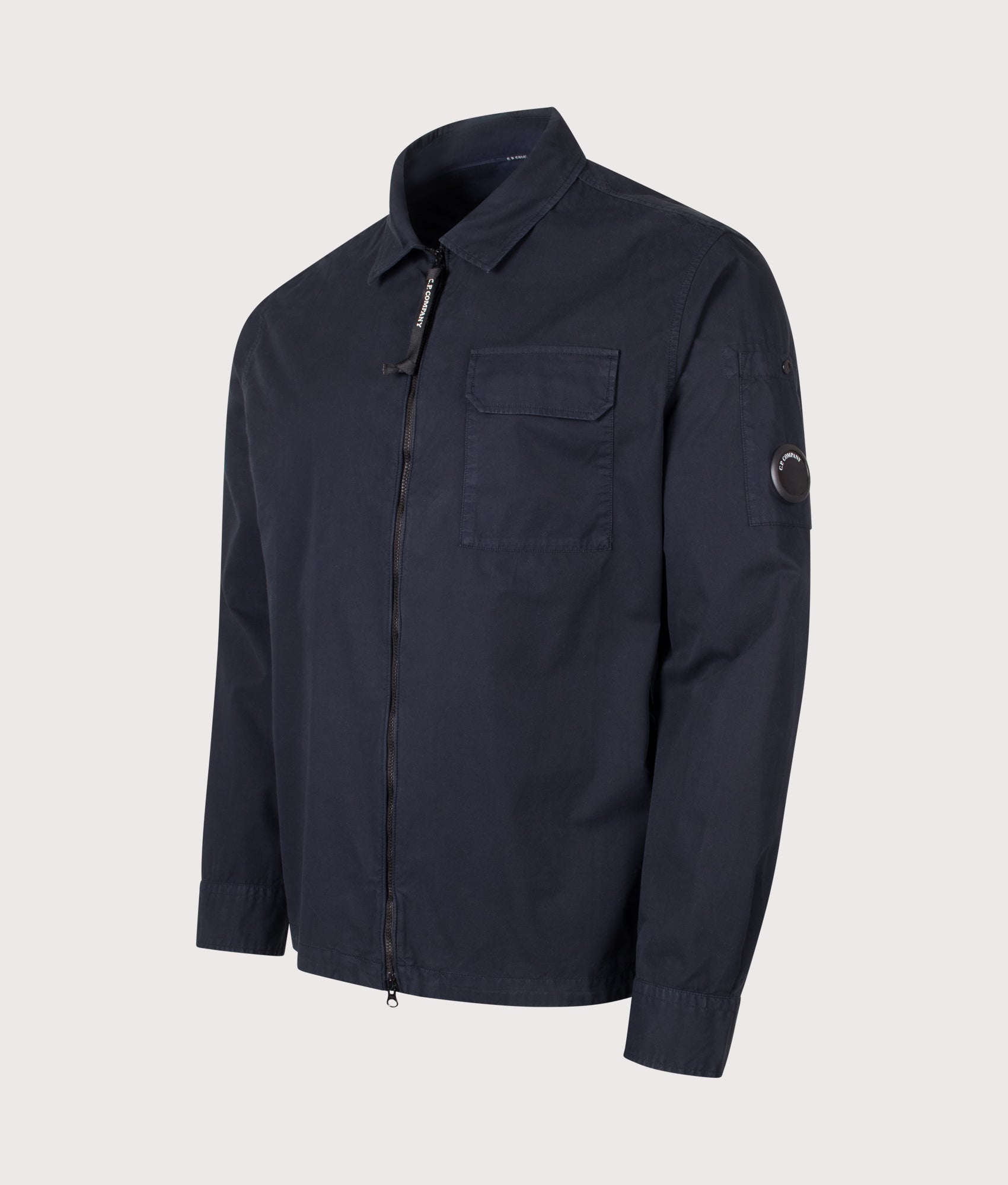 C.P. Company Organic Gabardine Zipped Lens Overshirt in Total Eclipse at EQVVS Menswear. Angled front shot.