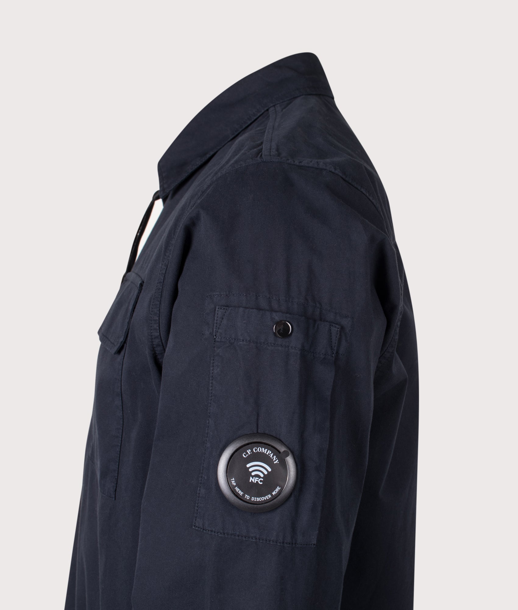 C.P. Company Organic Gabardine Zipped Lens Overshirt in Total Eclipse at EQVVS Menswear. NFC detail shot.