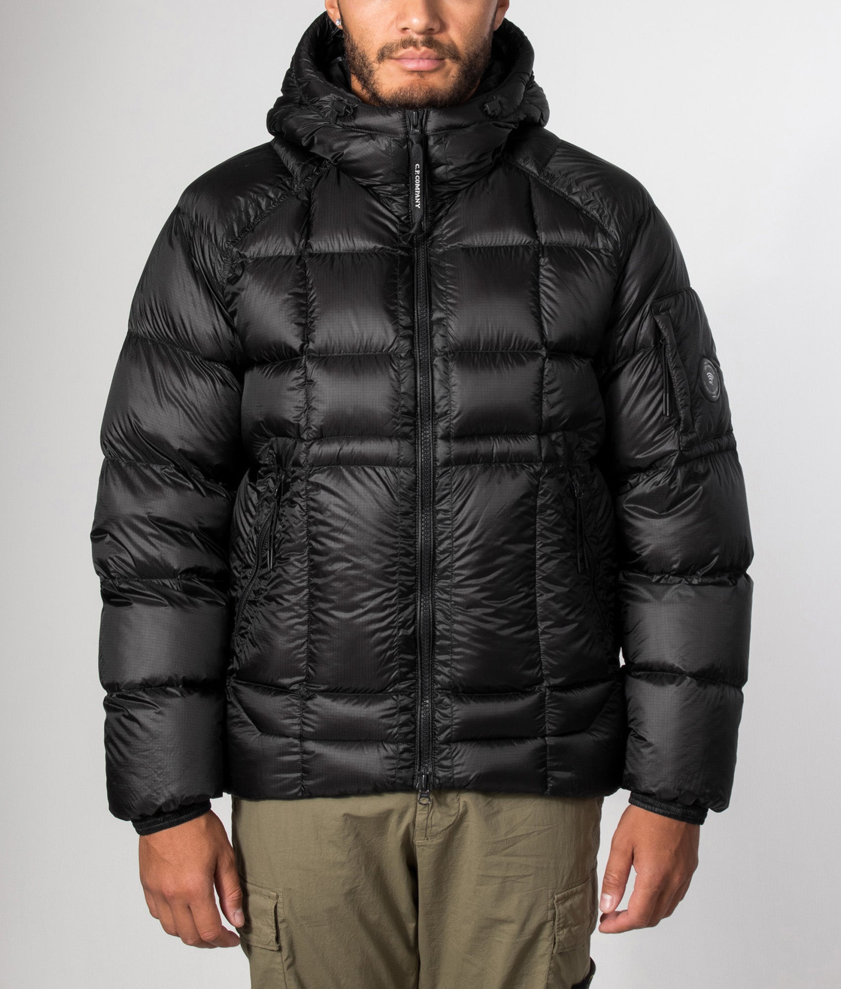 C.P. Company D.D. Shell Hooded Down Jacket in Black at EQVVS Menswear. Model front shot.