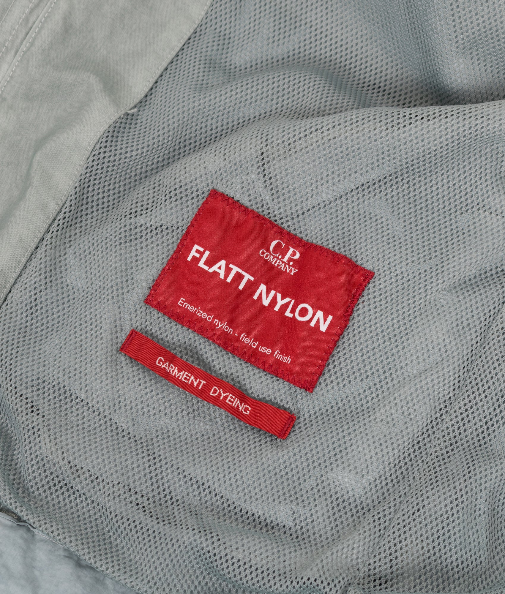 C.P. Company Flatt Nylon Mixed Goggle Overshirt in Silver blue at EQVVS Menswear. Label detail shot.