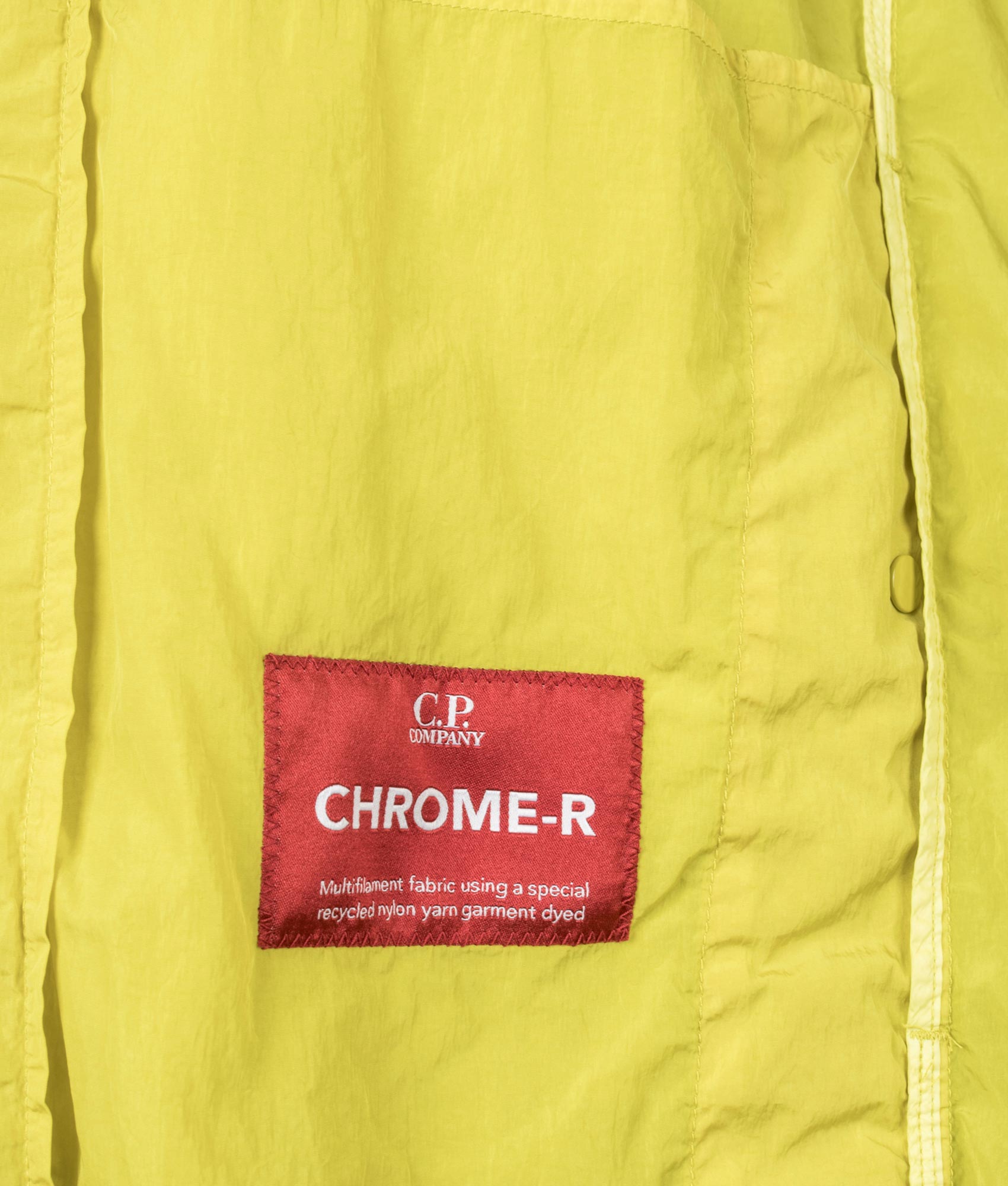 C.P. Company Chrome-R Hooded Lens Overshirt in Antique Moss at EQVVS Menswear. Label shot.