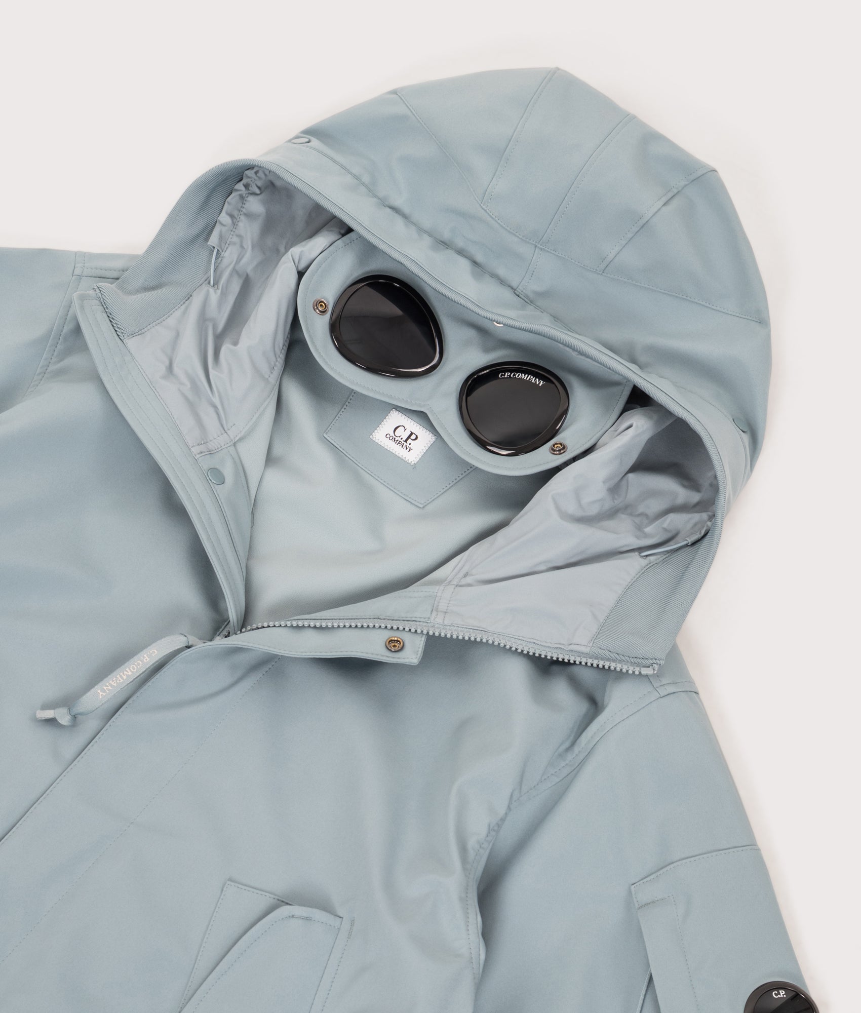 C.P. Company Shell-R Goggle Jacket in Silver Blue at EQVVS Menswear. Hood and goggle shot.