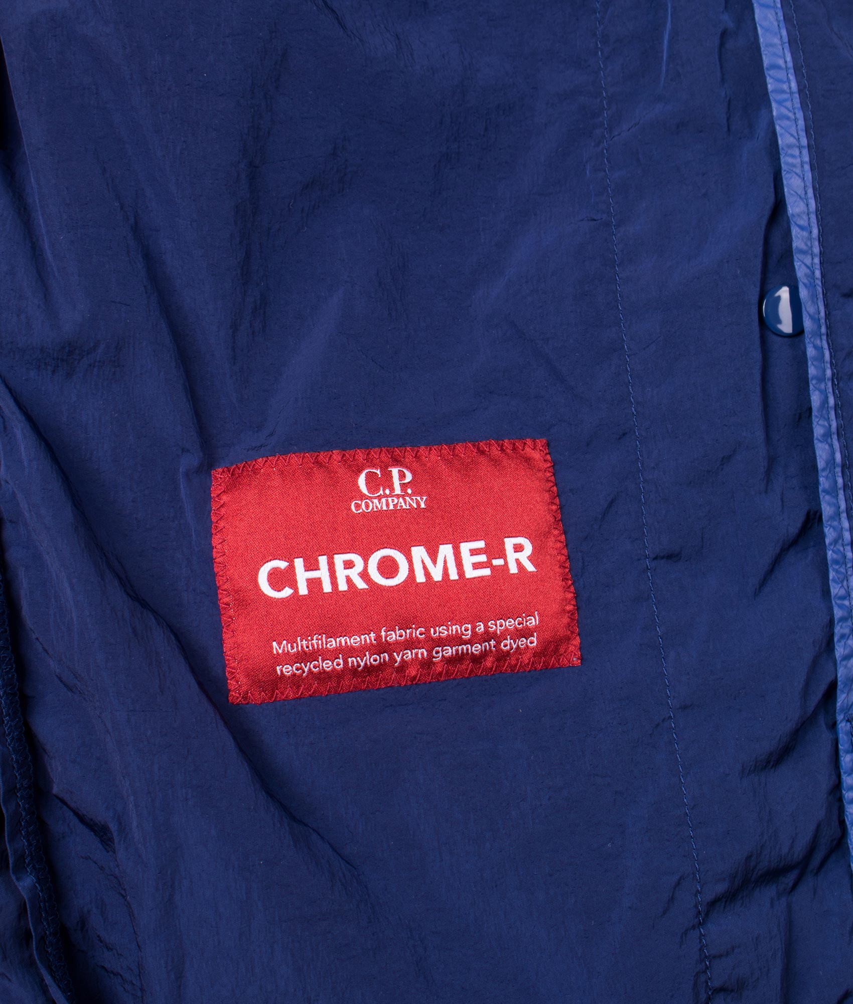 C.P. Company Chrome-R Hooded Lens Overshirt in Blueprint at EQVVS Menswear. Label shot.