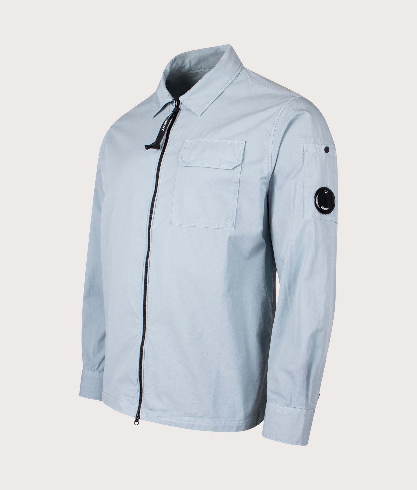 C.P Company Gabardine Zipped Lens Overshirt in Silver Blue at EQVVS Menswear. Front shot.
