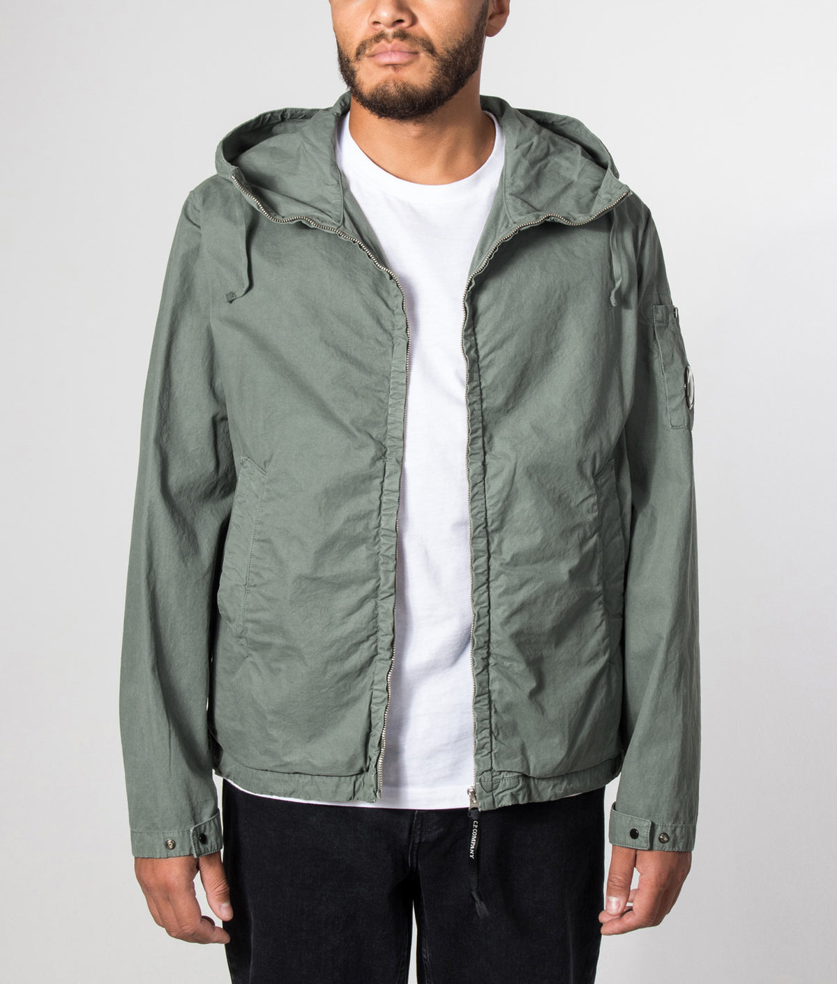 C.P. Company Micro-Reps Hooded Lens Jacket in Laurel Wreath at EQVVS Menswear. Model front shot.