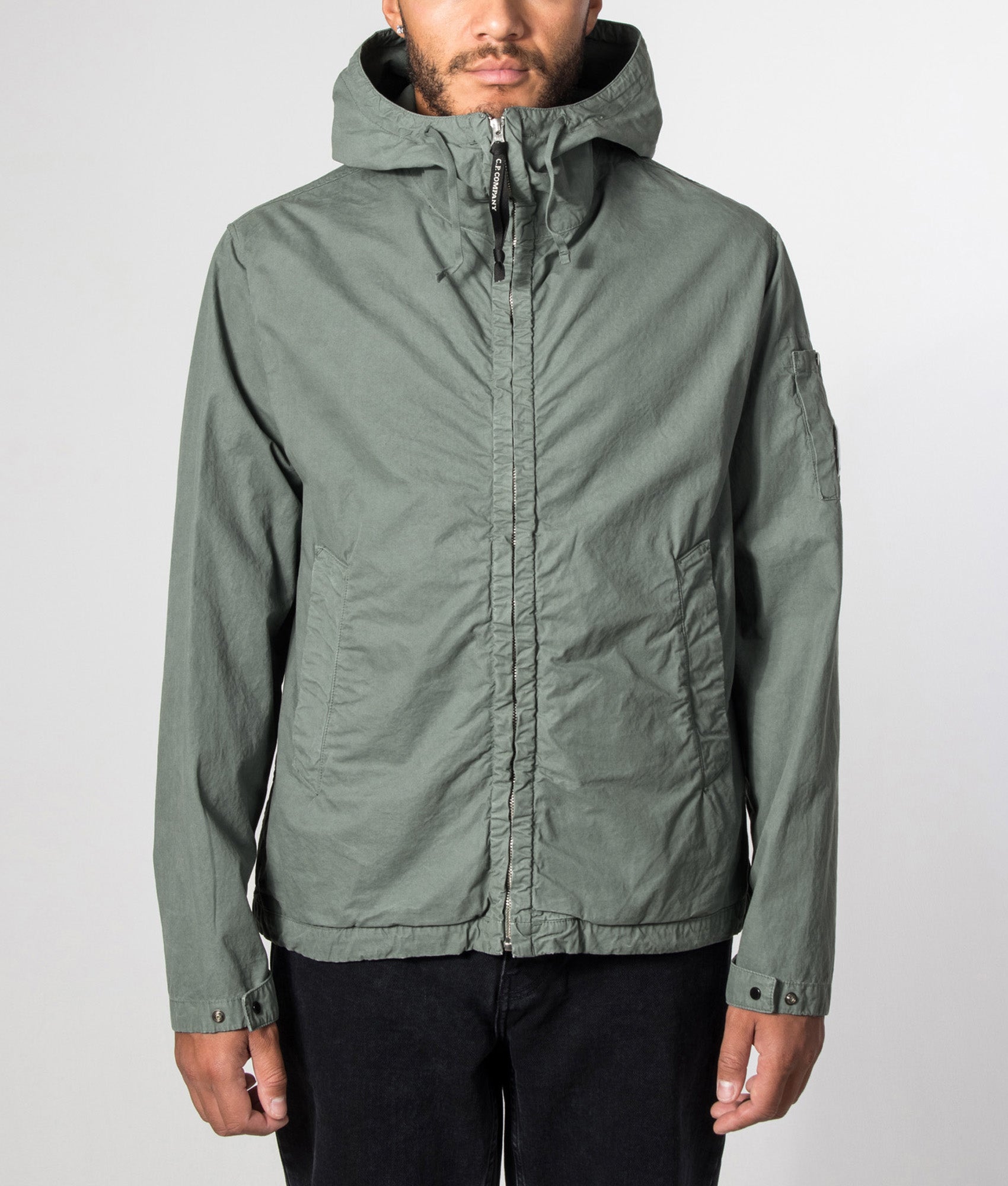 C.P. Company Micro-Reps Hooded Lens Jacket in Laurel Wreath at EQVVS Menswear. Model front shot.