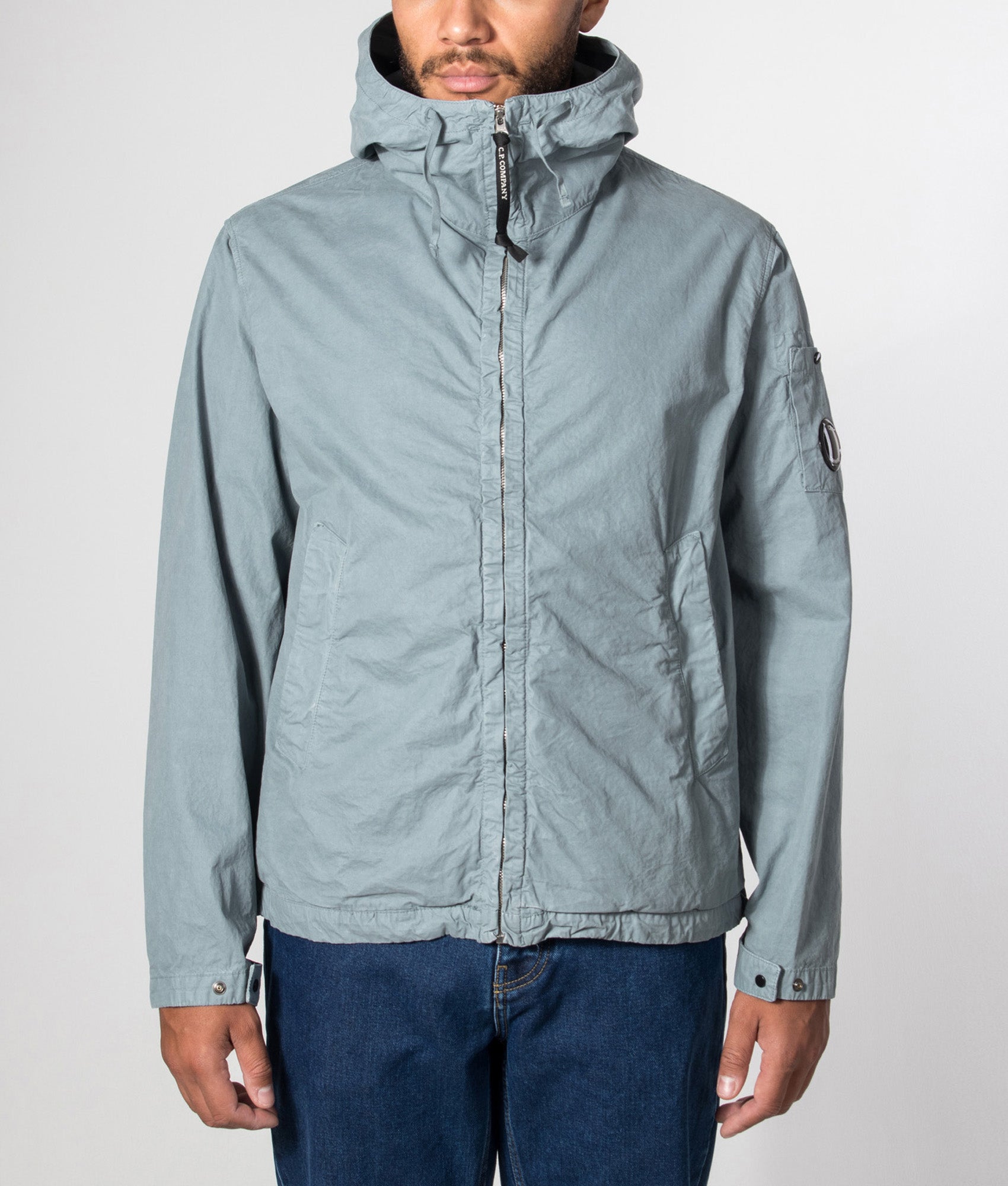 C.P. Company Micro-Reps Hooded Lens Jacket in Silver Blue at EQVVS Menswear. Model front shot.