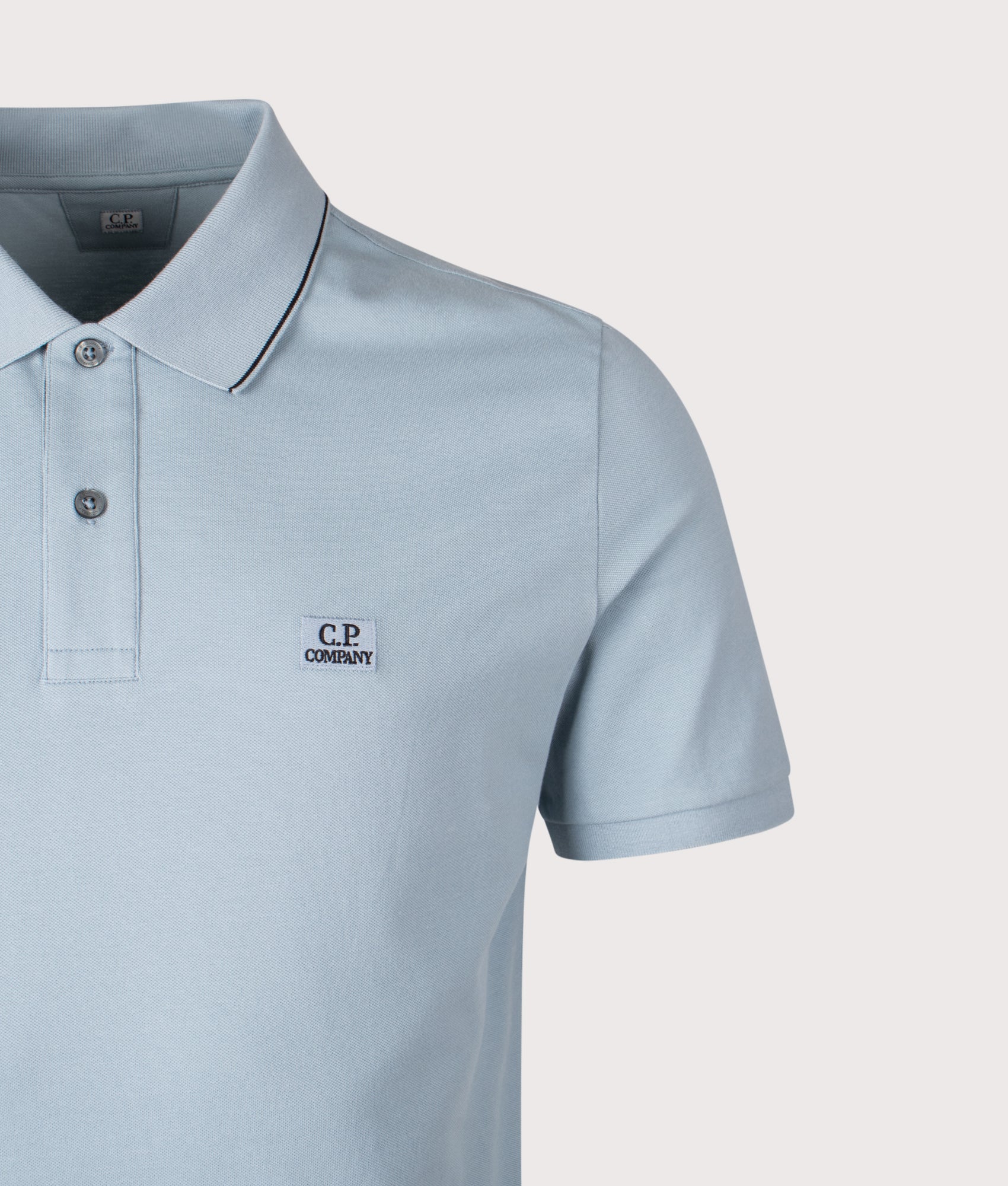 C.P. Company Stretch Piquet Short Sleeve Logo Polo Shirt in Silver Blue at EQVVS Menswear. Detail shot.