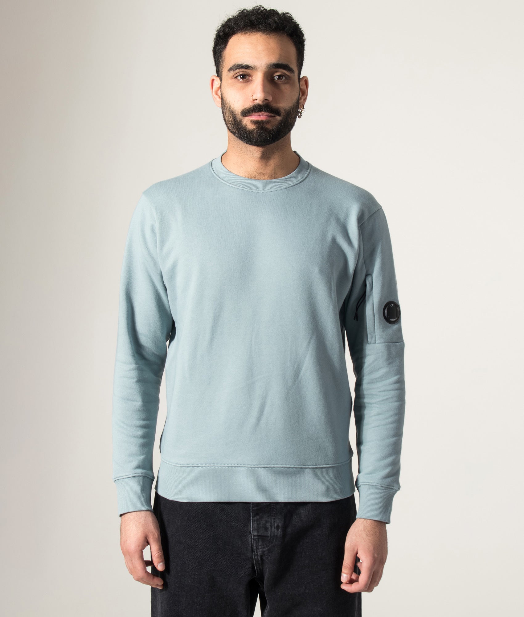 C.P. Company Diagonal Raised Fleece Lens Sweatshirt in Silver Blue at EQVVS Menswear. Model front shot.
