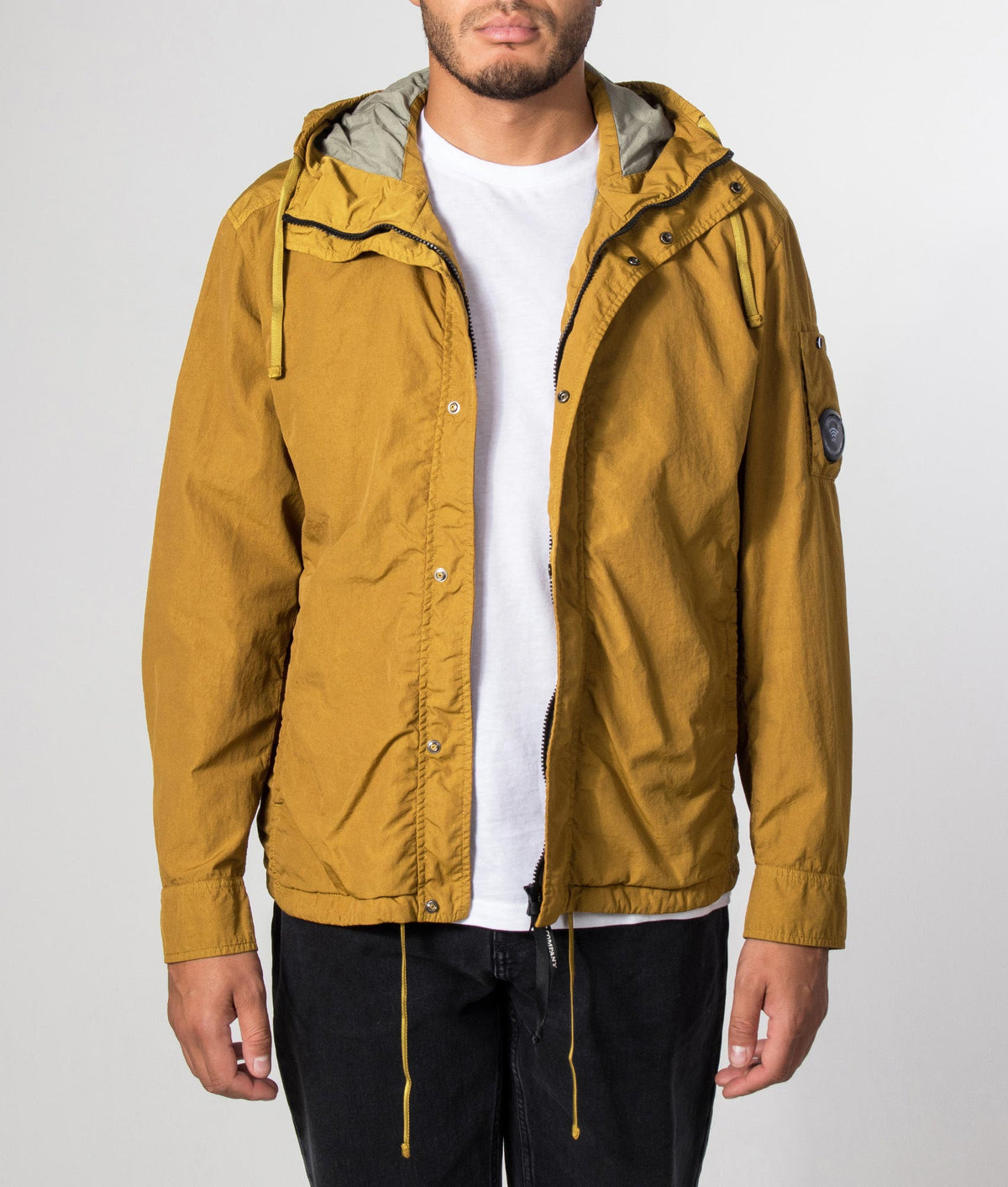 C.P. Company T-ST Nylon Hooded Lens Overshirt in Buck Thorn Brown at EQVVS Menswear. Model front shot.