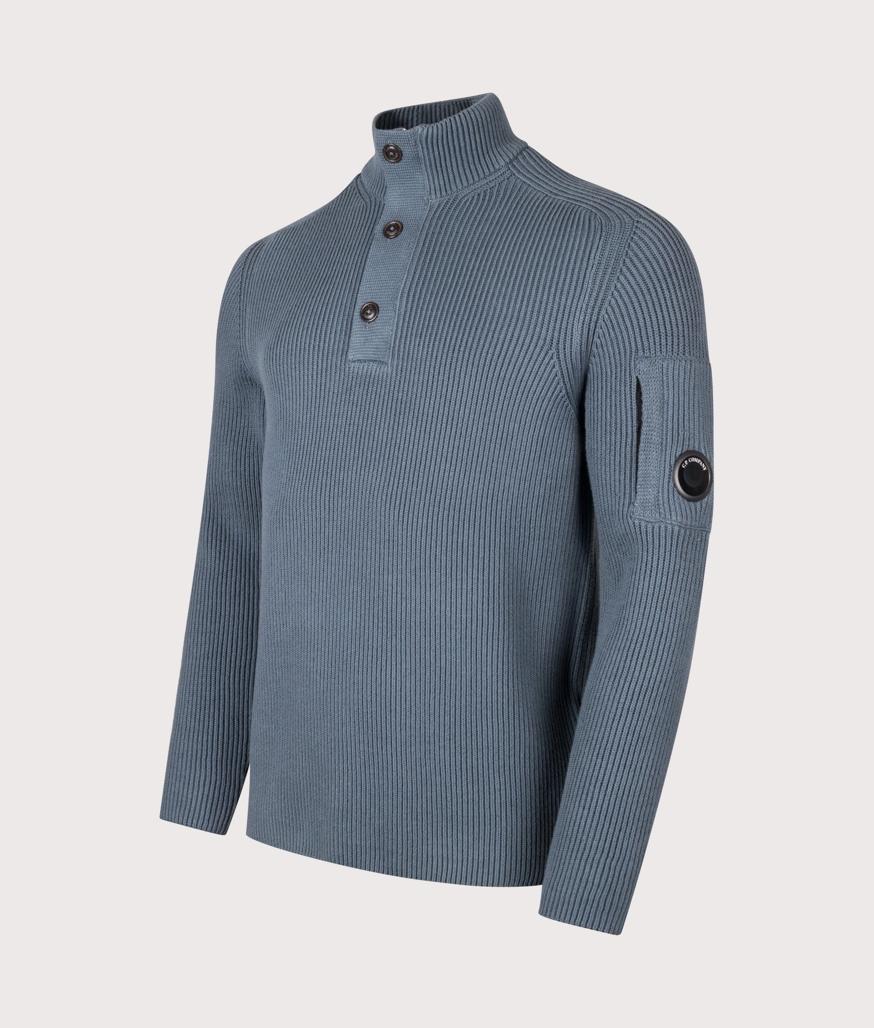 C.P. Company Full Rib Cotton Half Button Lens Jumper in Orion Blue at EQVVS Menswear. Angled front shot.