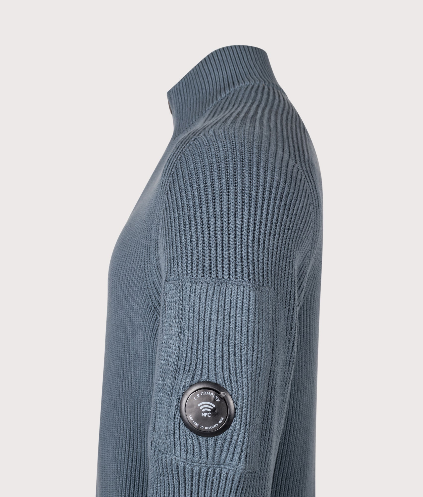 C.P. Company Full Rib Cotton Half Button Lens Jumper in Orion Blue at EQVVS Menswear. NFC detail shot.