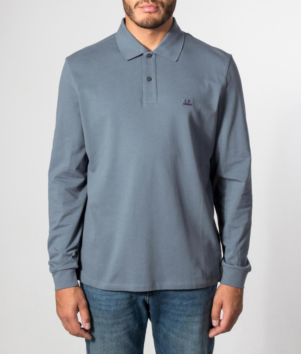 C.P. Company Long Sleeve Stretch Piquet Logo Polo Shirt in Orion Blue at EQVVS Menswear. Model front shot.