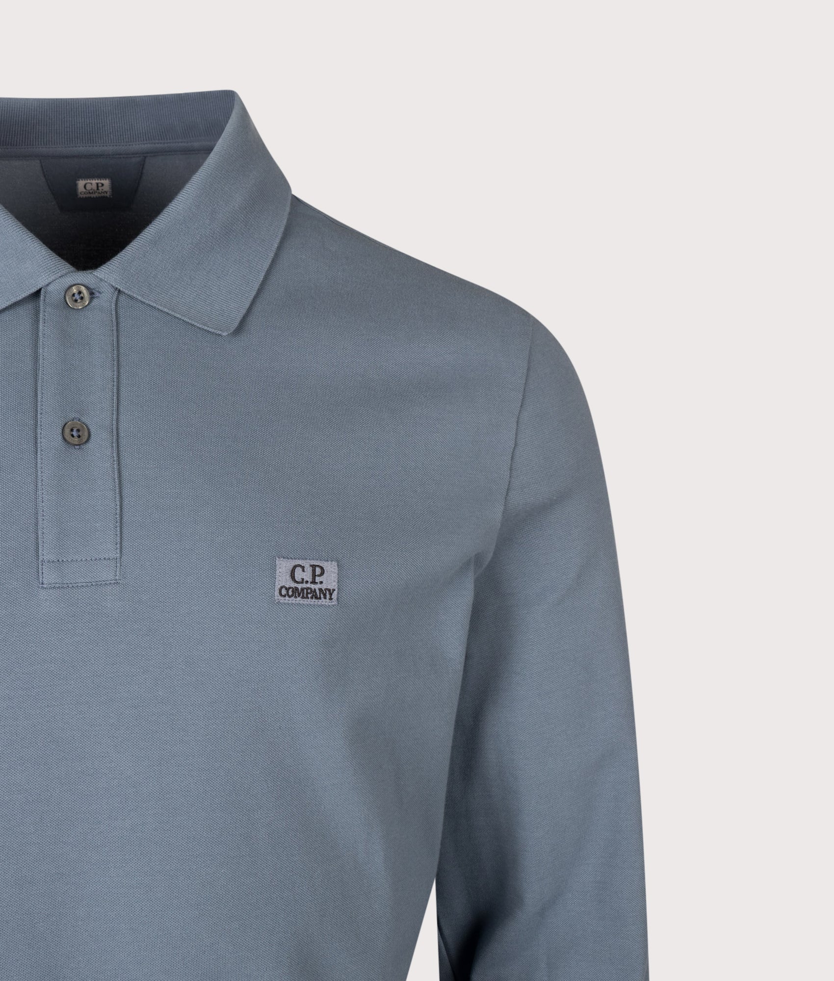 C.P. Company Long Sleeve Stretch Piquet Logo Polo Shirt in Orion Blue at EQVVS Menswear. Detail shot.