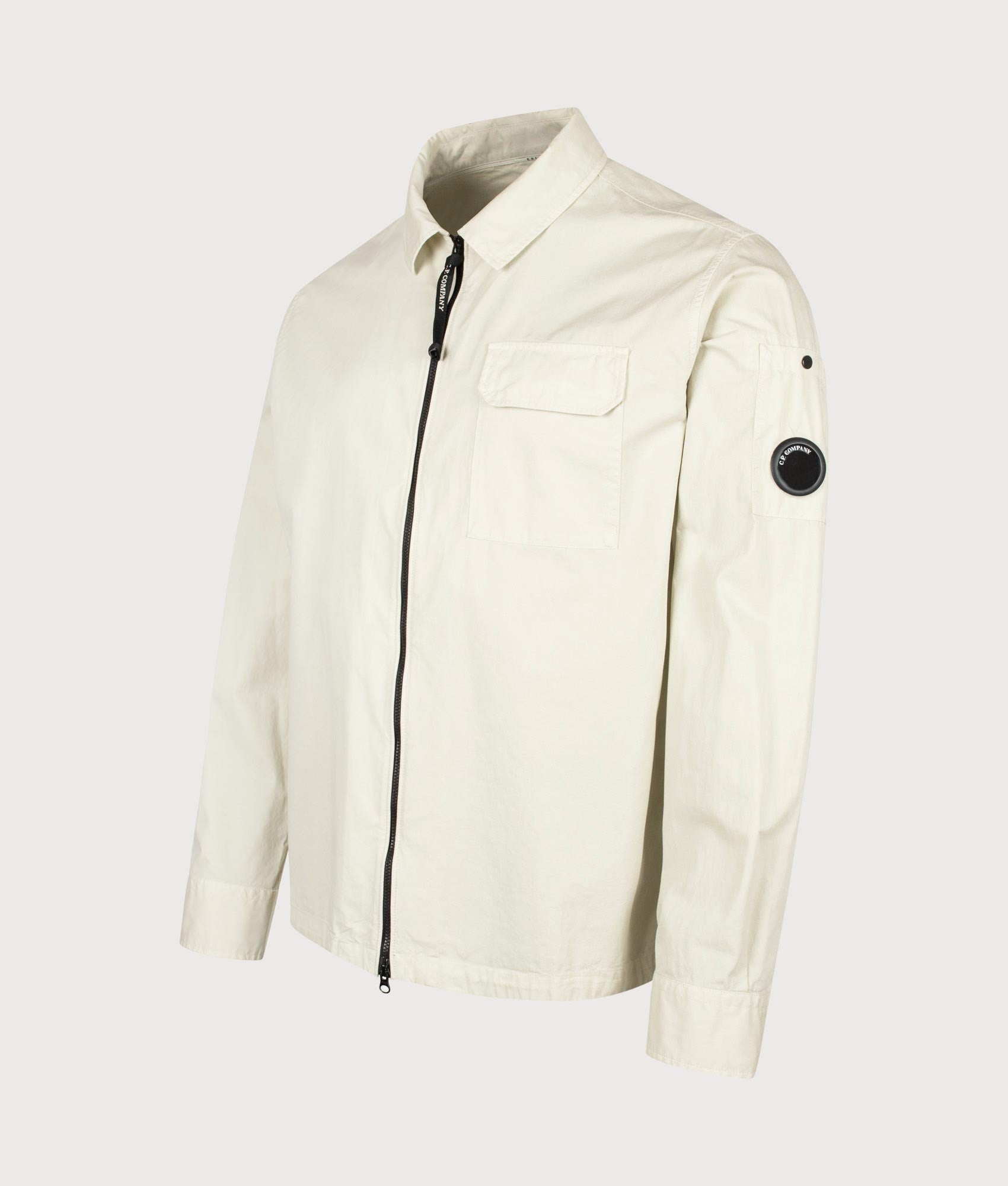 C.P. Company Organic Gabardine Zipped Lens Overshirt in Silver Birch at EQVVS Menswear. Angled front shot.