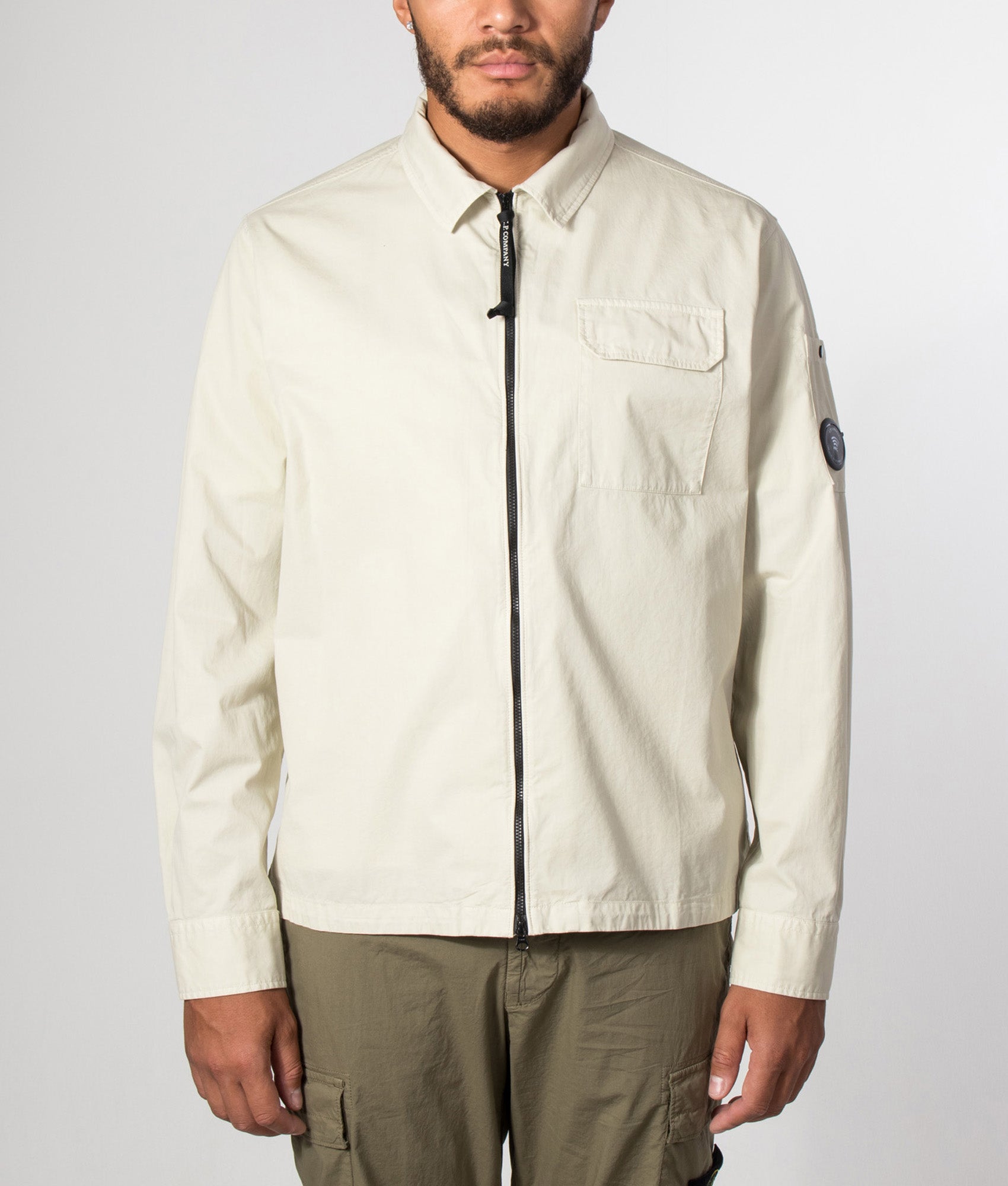 C.P. Company Organic Gabardine Zipped Lens Overshirt in Silver Birch at EQVVS Menswear. Model front shot.