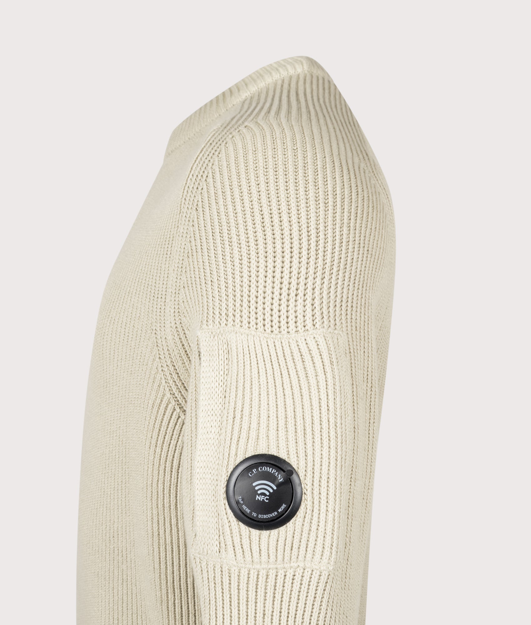 C.P. Company Full Rib Cotton Crewneck Lens Jumper in Silver Birch at EQVVS Menswear. NFC Detail shot.