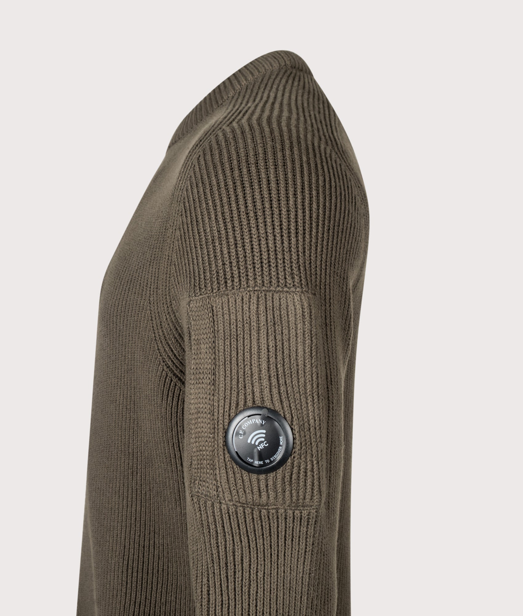 C.P. Company Full Rib Cotton Crewneck Lens Jumper in Ivy Green at EQVVS Menswear. NFC Detail shot.