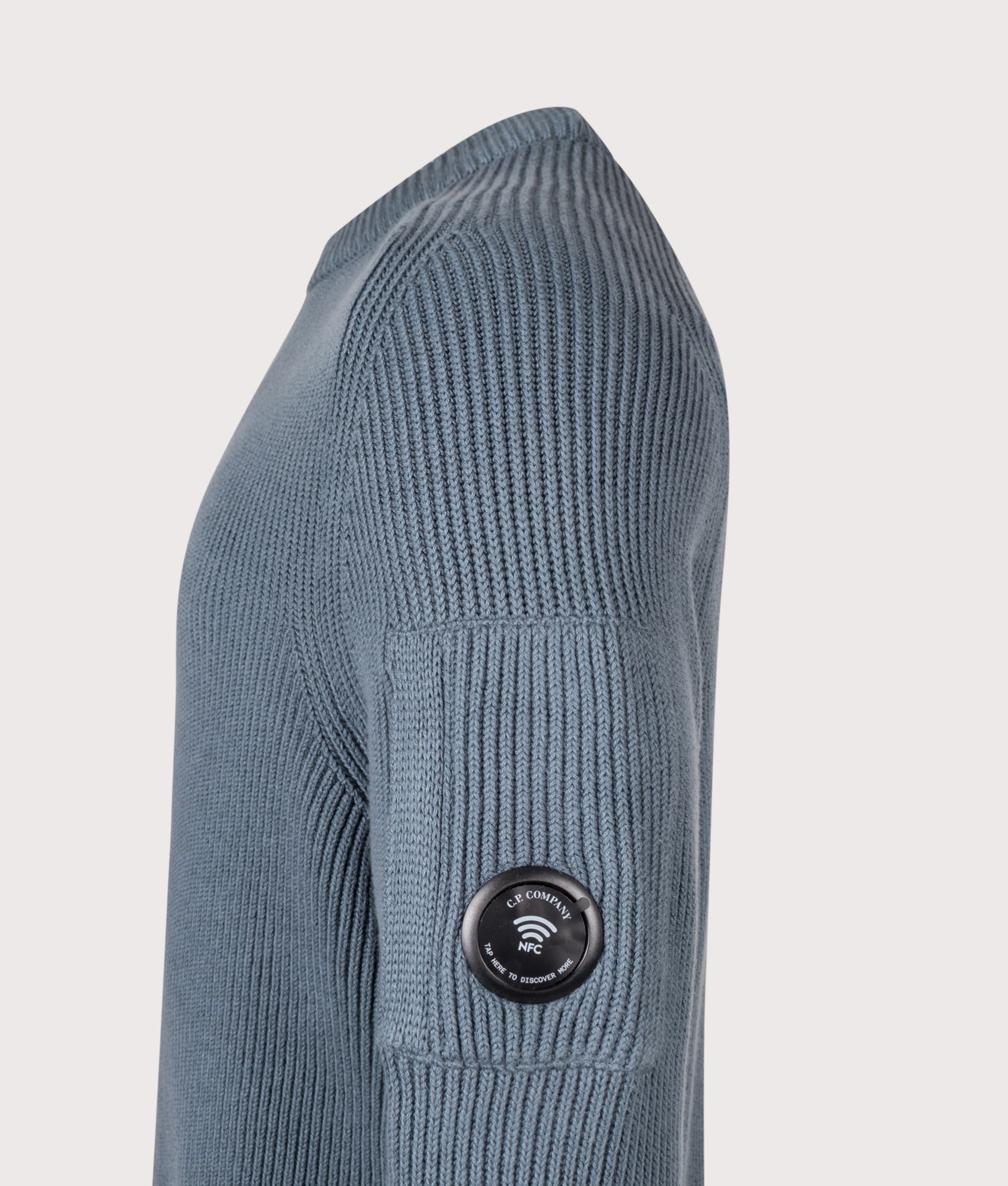 C.P. Company Full Rib Cotton Crewneck Lens Jumper in Orion Blue at EQVVS Menswear. NFC detail shot.