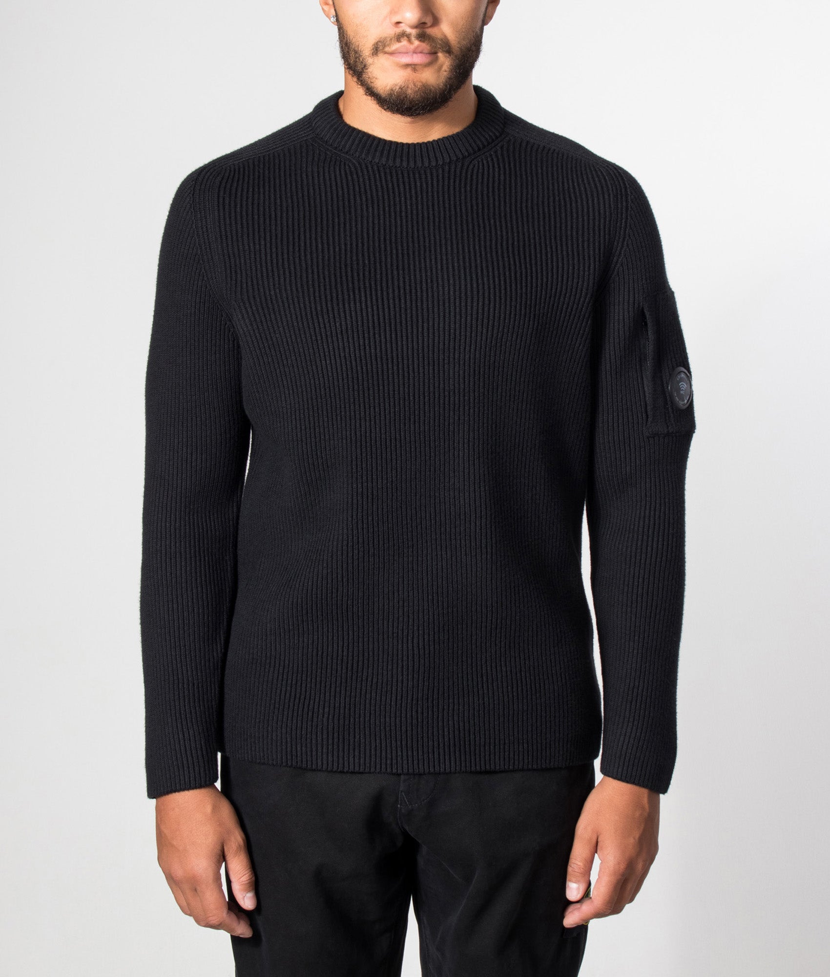 C.P. Company Full Rib Cotton Crewneck Lens Jumper in Black at EQVVS Menswear. Model front shot.