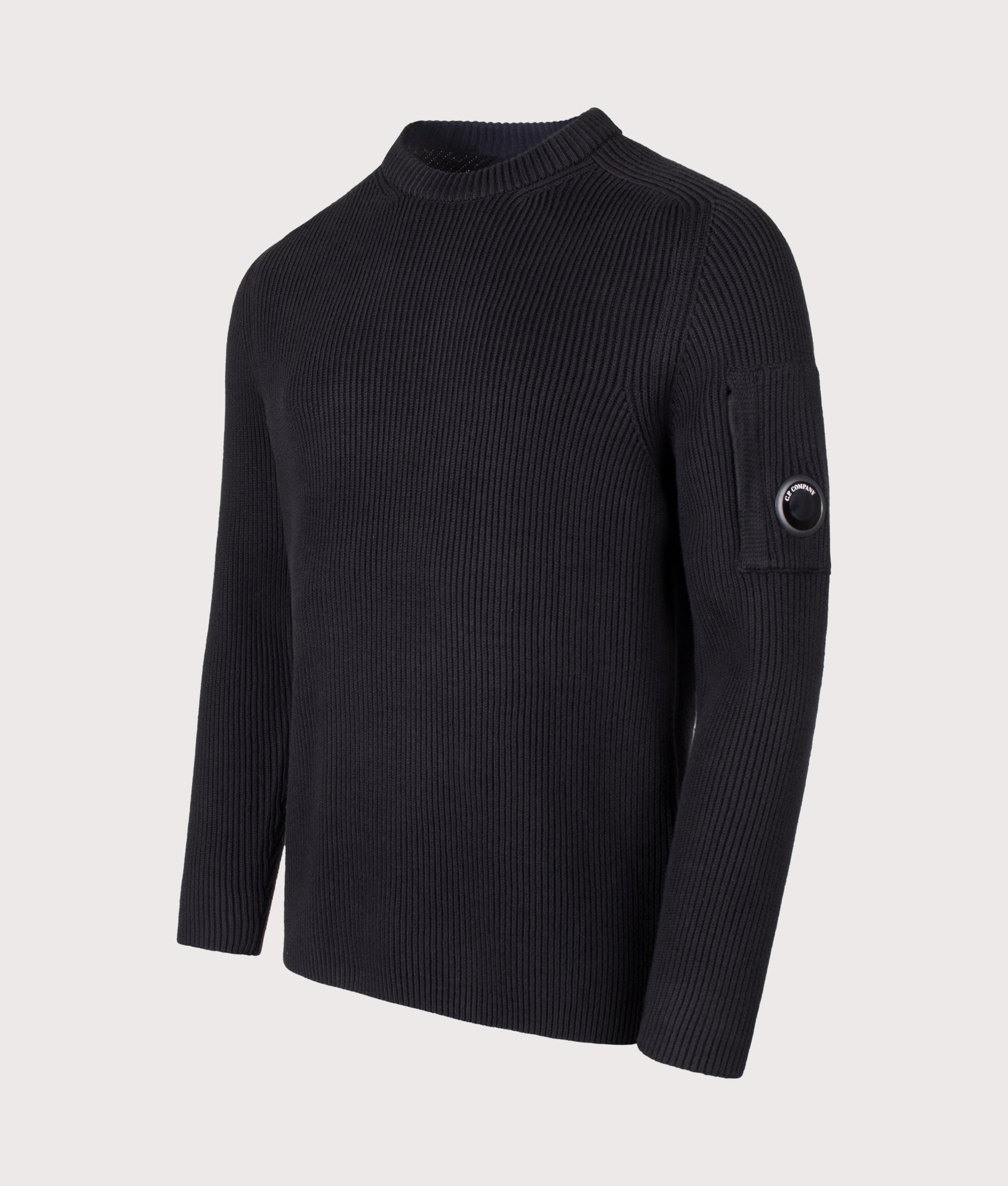 C.P. Company Full Rib Cotton Crewneck Lens Jumper in Black at EQVVS Menswear. Angled front shot.
