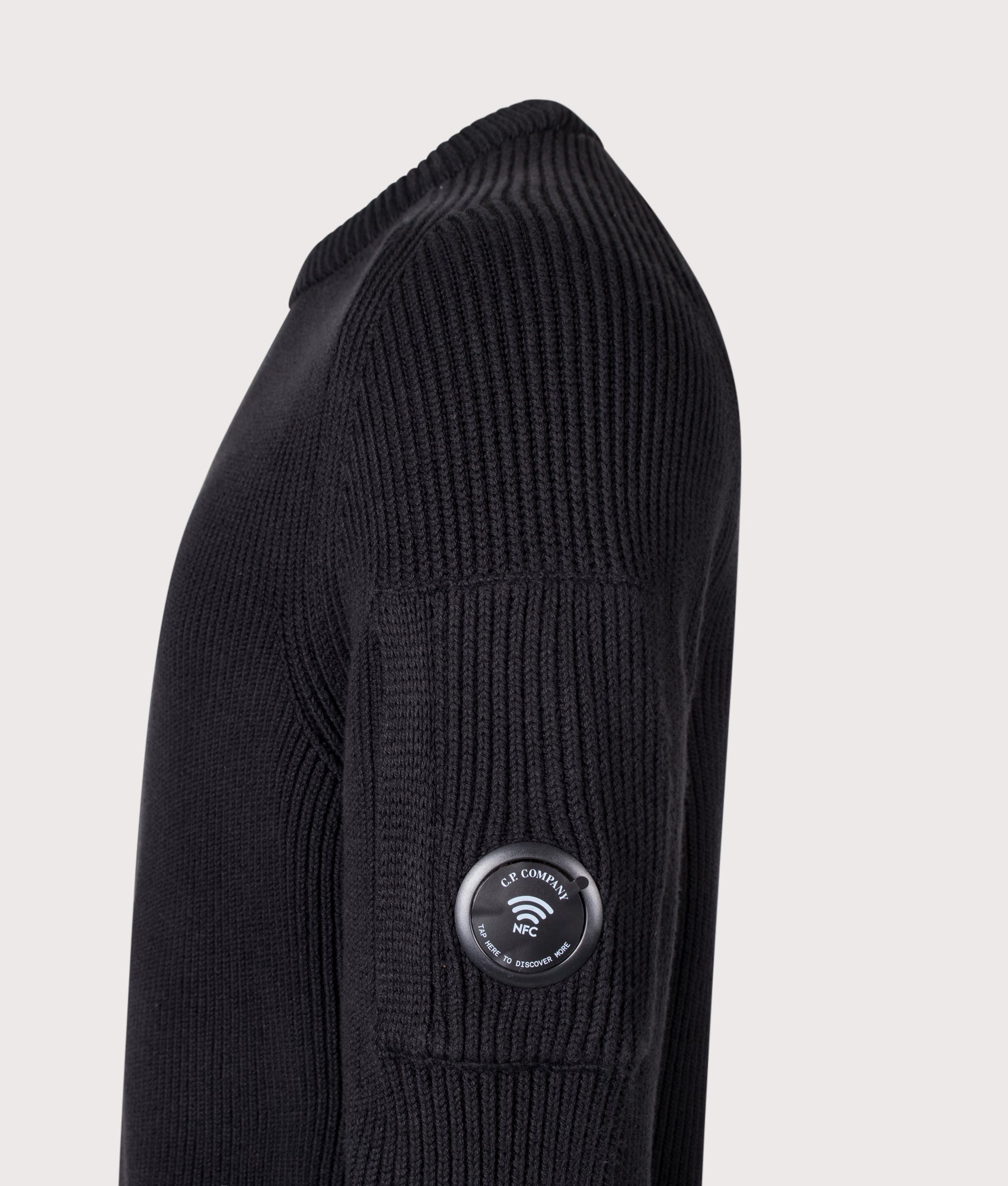 C.P. Company Full Rib Cotton Crewneck Lens Jumper in Black at EQVVS Menswear. NFC Detail shot.