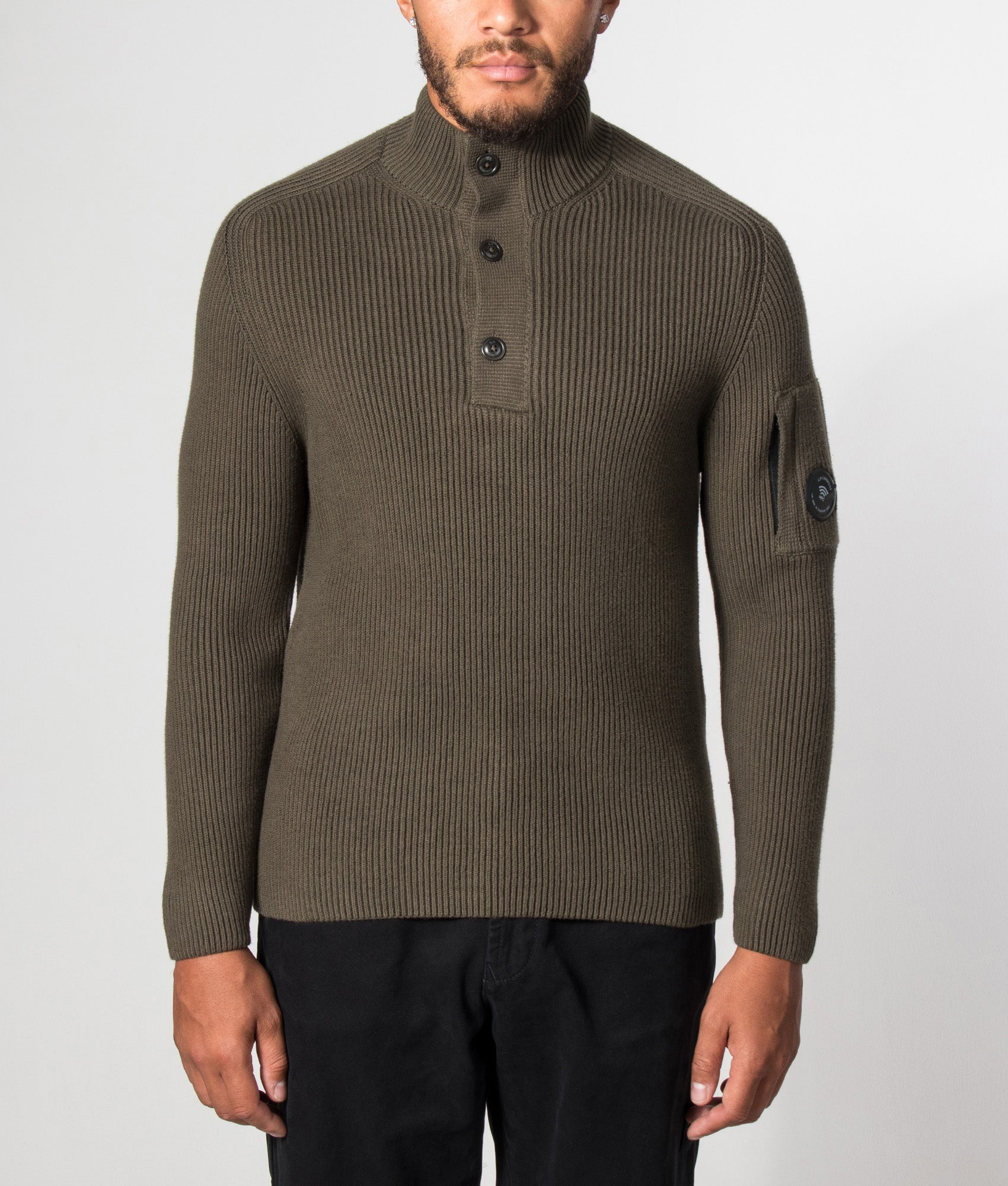 C.P. Company Full Rib Cotton Half Button Lens Jumper in Ivy Green at EQVVS Menswear. Model front shot.