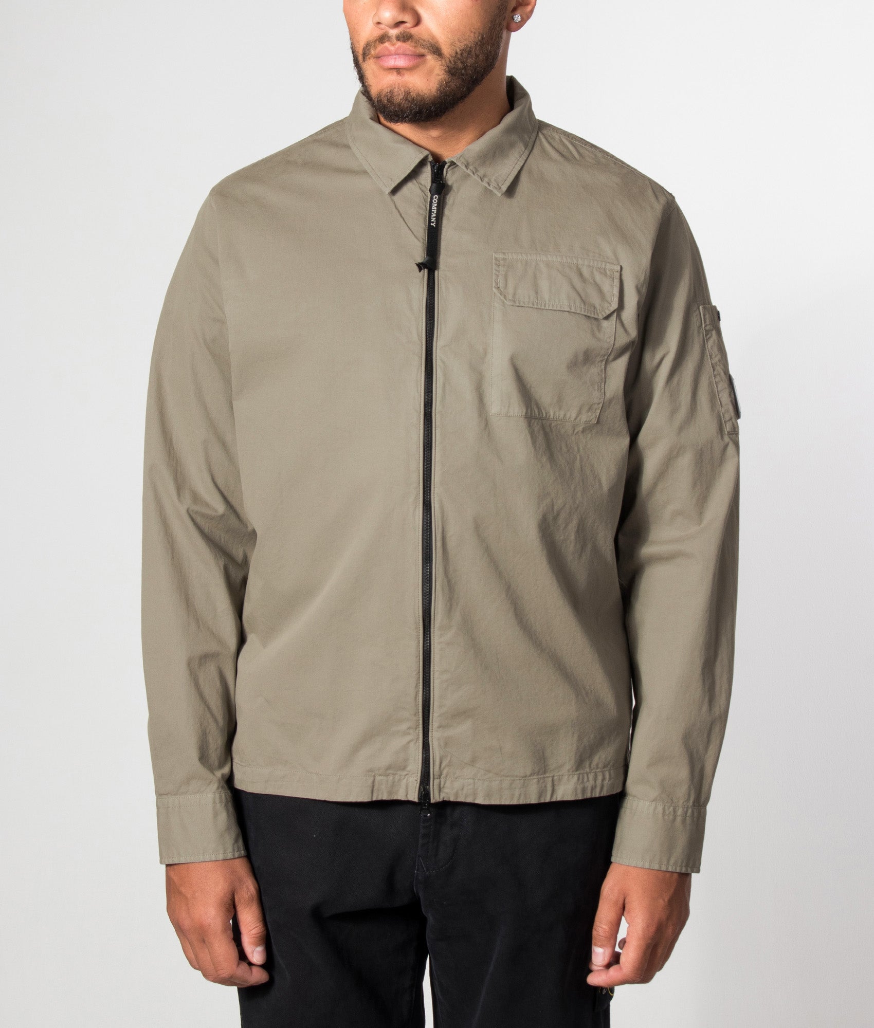 C.P. Company Organic Gabardine Zipped Lens Overshirt in Fallen Rock at EQVVS Menswear. Model front shot.