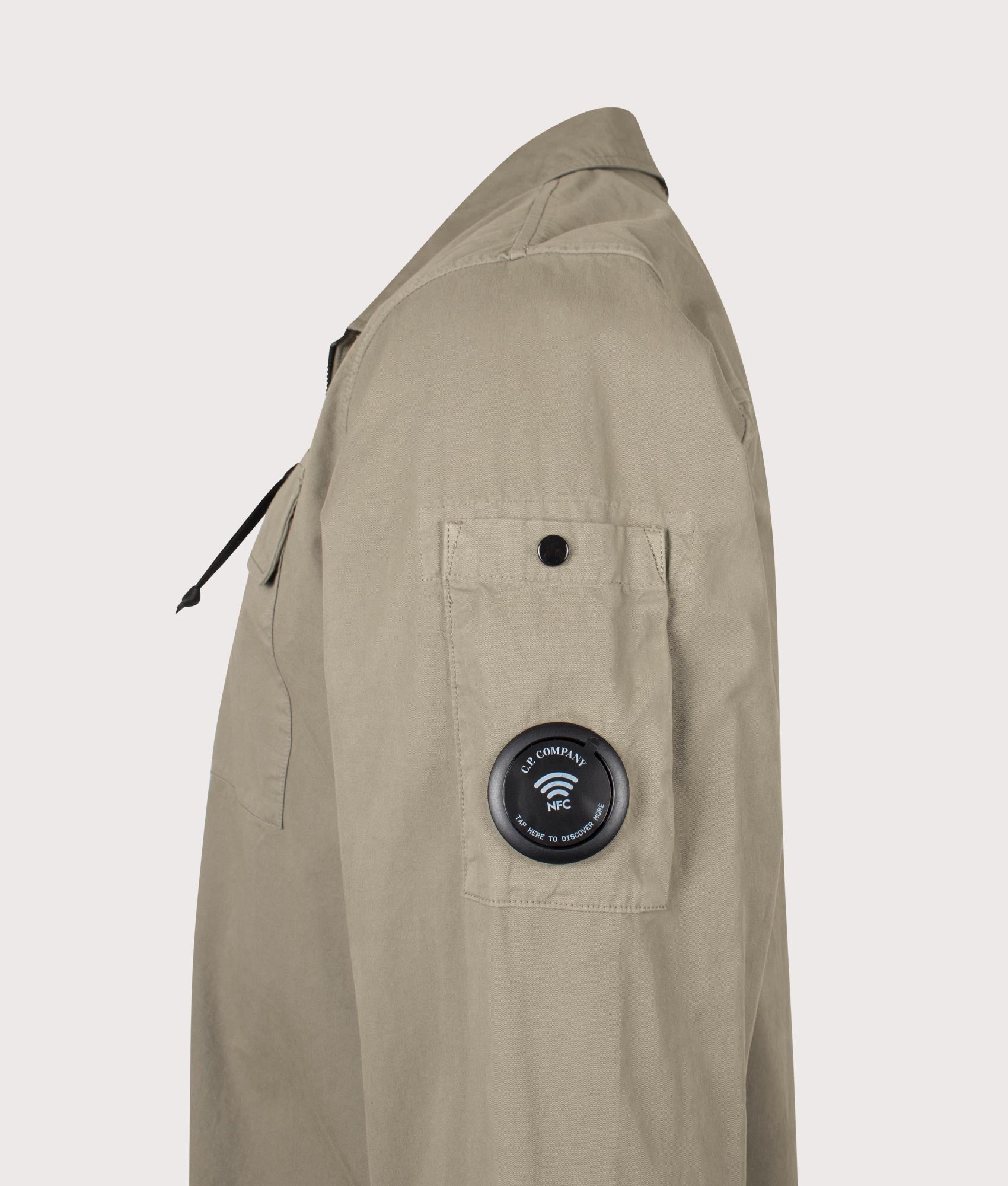 C.P. Company Organic Gabardine Zipped Lens Overshirt in Fallen Rock at EQVVS Menswear. NFC detail shot.