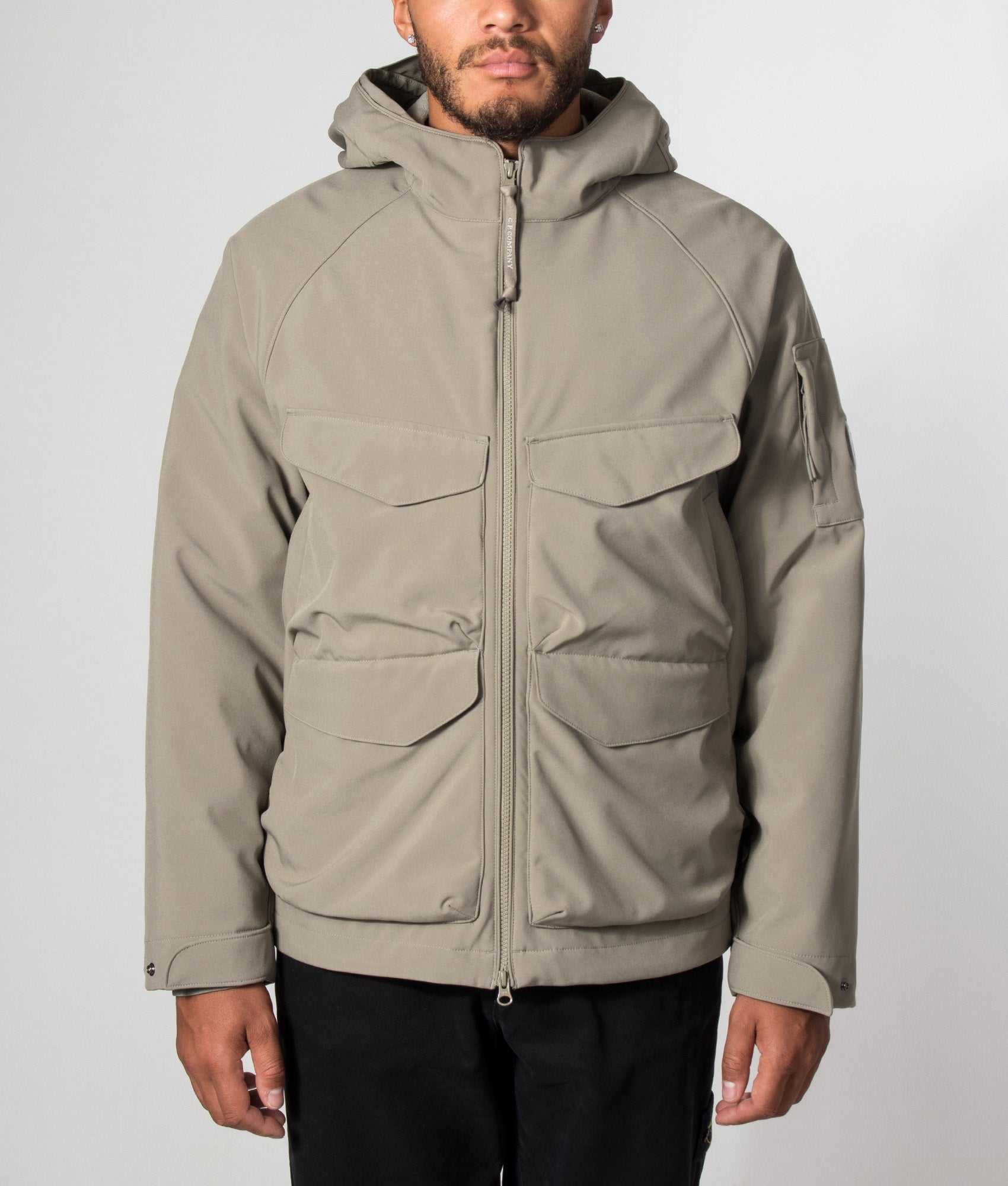 C.P. Company C.P. Shell-R Padded Hooded Lens Jacket in Fallen Rock at EQVVS Menswear. Model front shot.