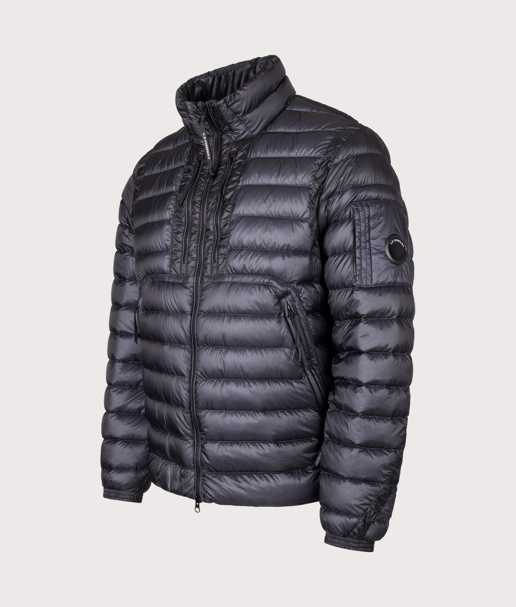 C.P. Company D.D. Shell Lens Down Jacket in Black at EQVVS Menswear. Angled front shot.