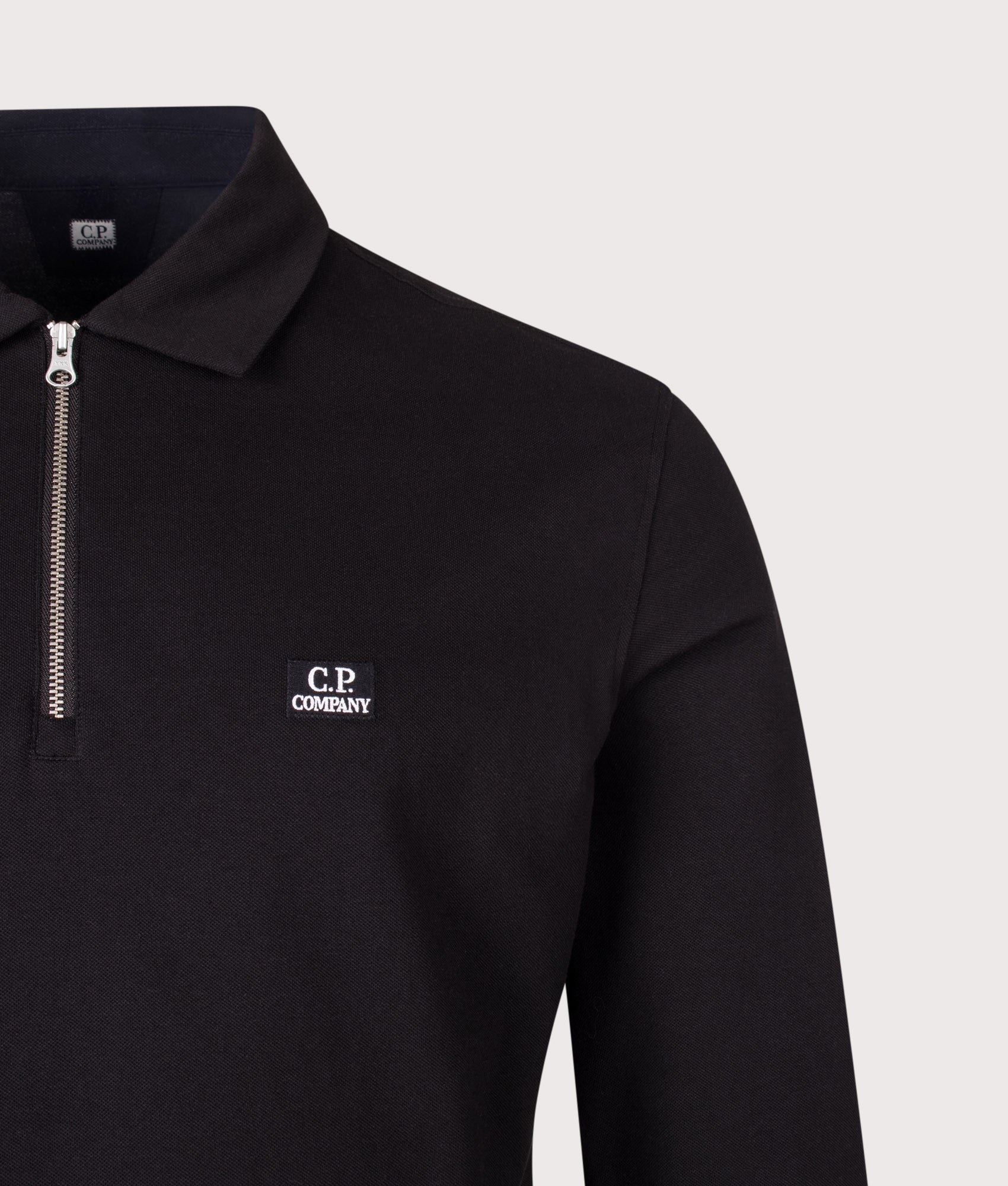 C.P. Company Long Sleeve Stretch Piquet Zip Polo Shirt in Black at EQVVS Menswear. Detail shot.