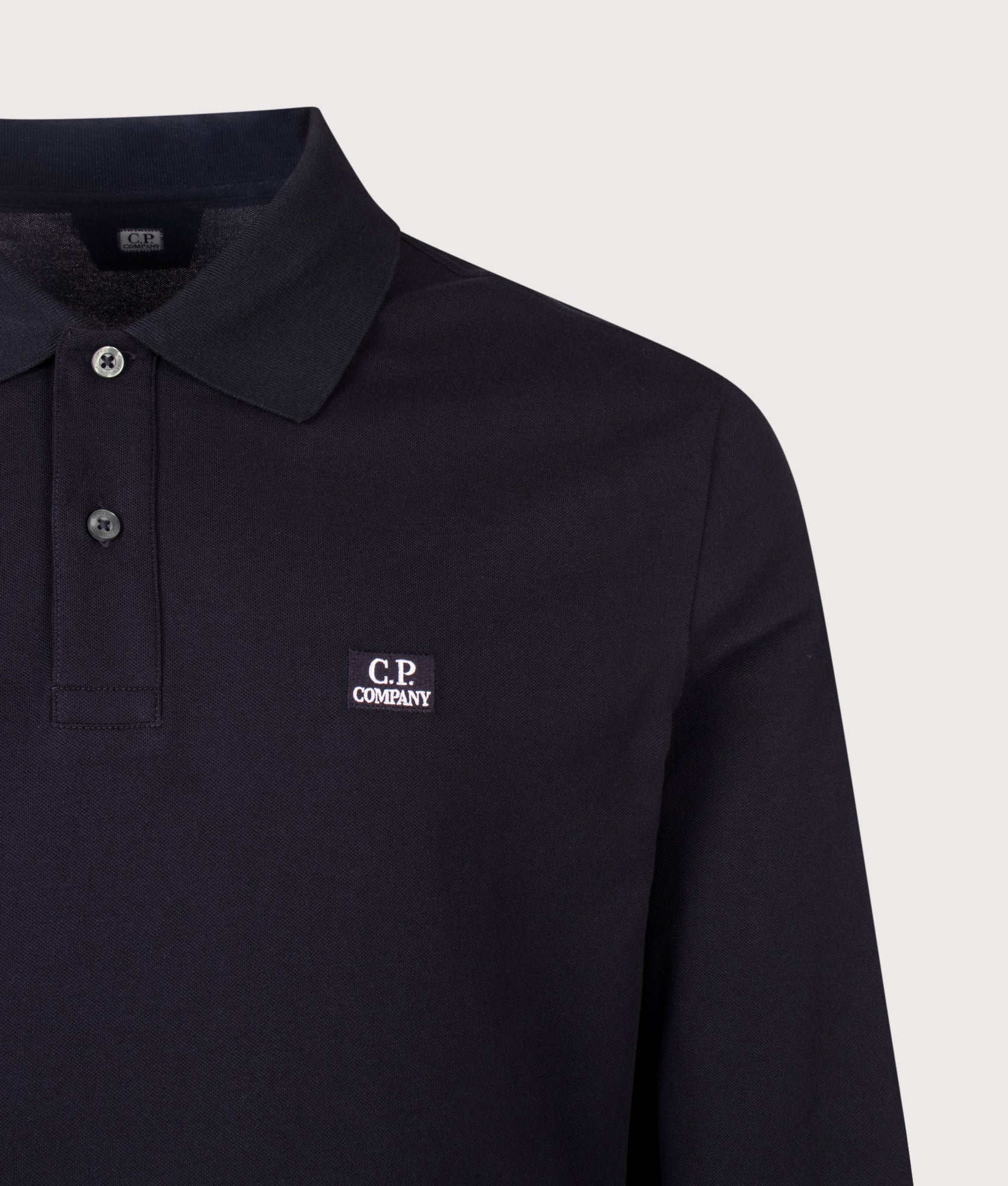 C.P. Company Long Sleeve Stretch Piquet Logo Polo Shirt in Total Eclipse at EQVVS Menswear. Detail shot.
