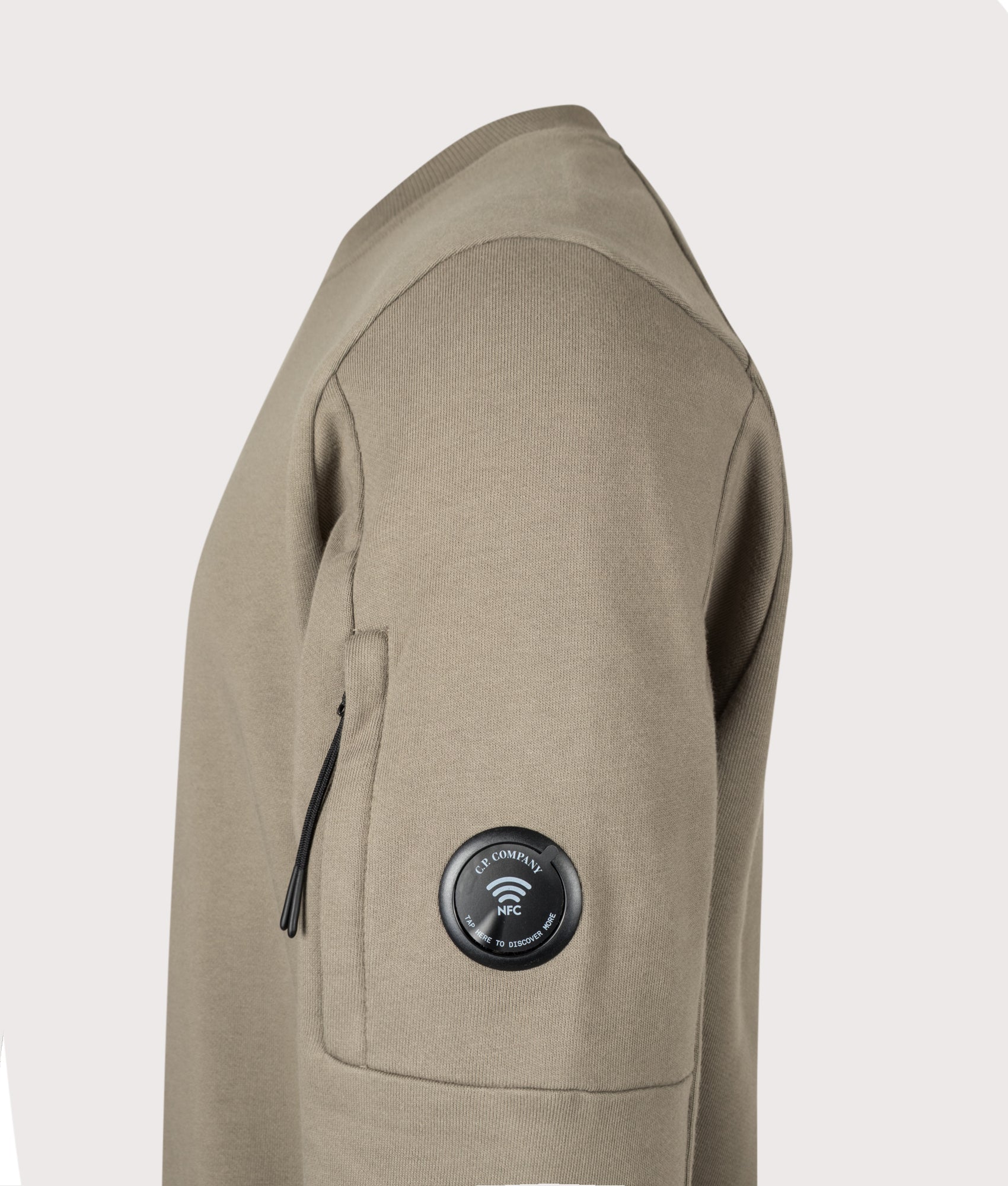 C.P. Company Diagonal Raised Fleece Crewneck Lens Sweatshirt in Fallen Rock at EQVVS Menswear. NFC Detail shot.
