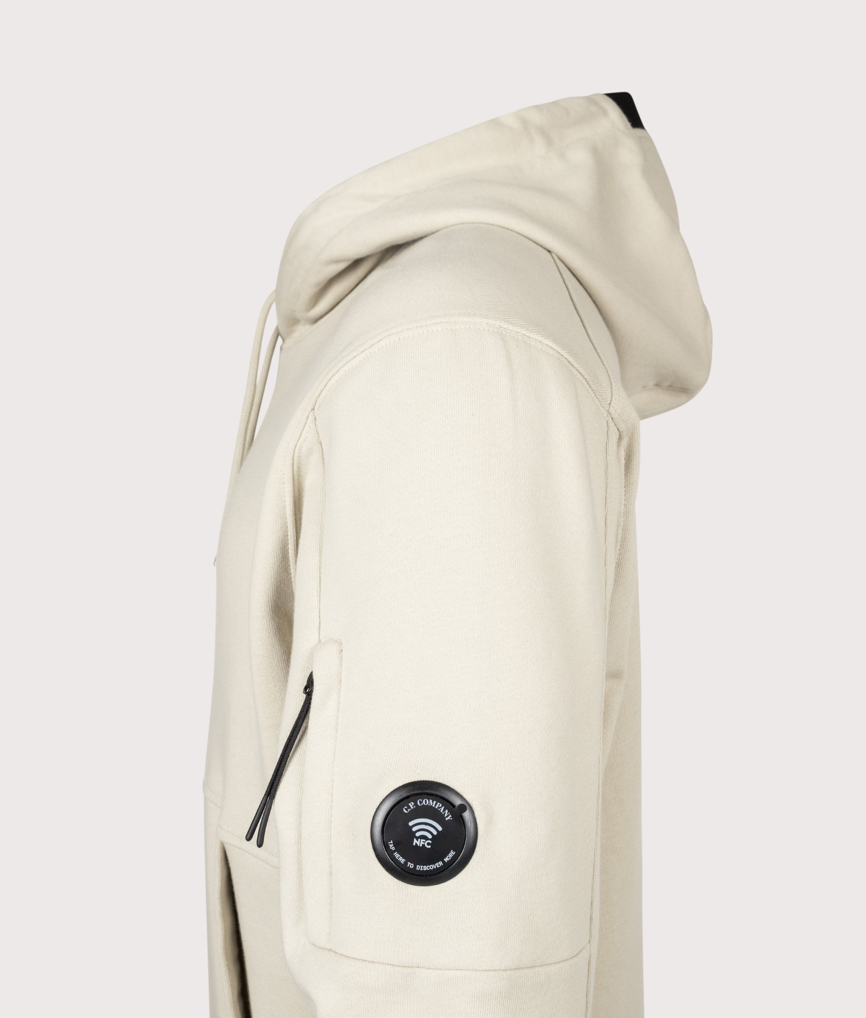 C.P. Company Diagonal Raised Fleece Lens Hoodie in Silver Birch at EQVVS Menswear. NFC Detail shot.