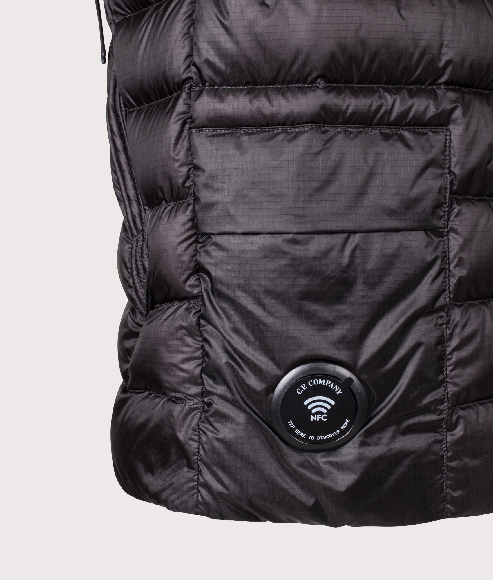 C.P. Company Dd-Shell Down Lens Gilet in Black at EQVVS Menswear. NFC detail shot.