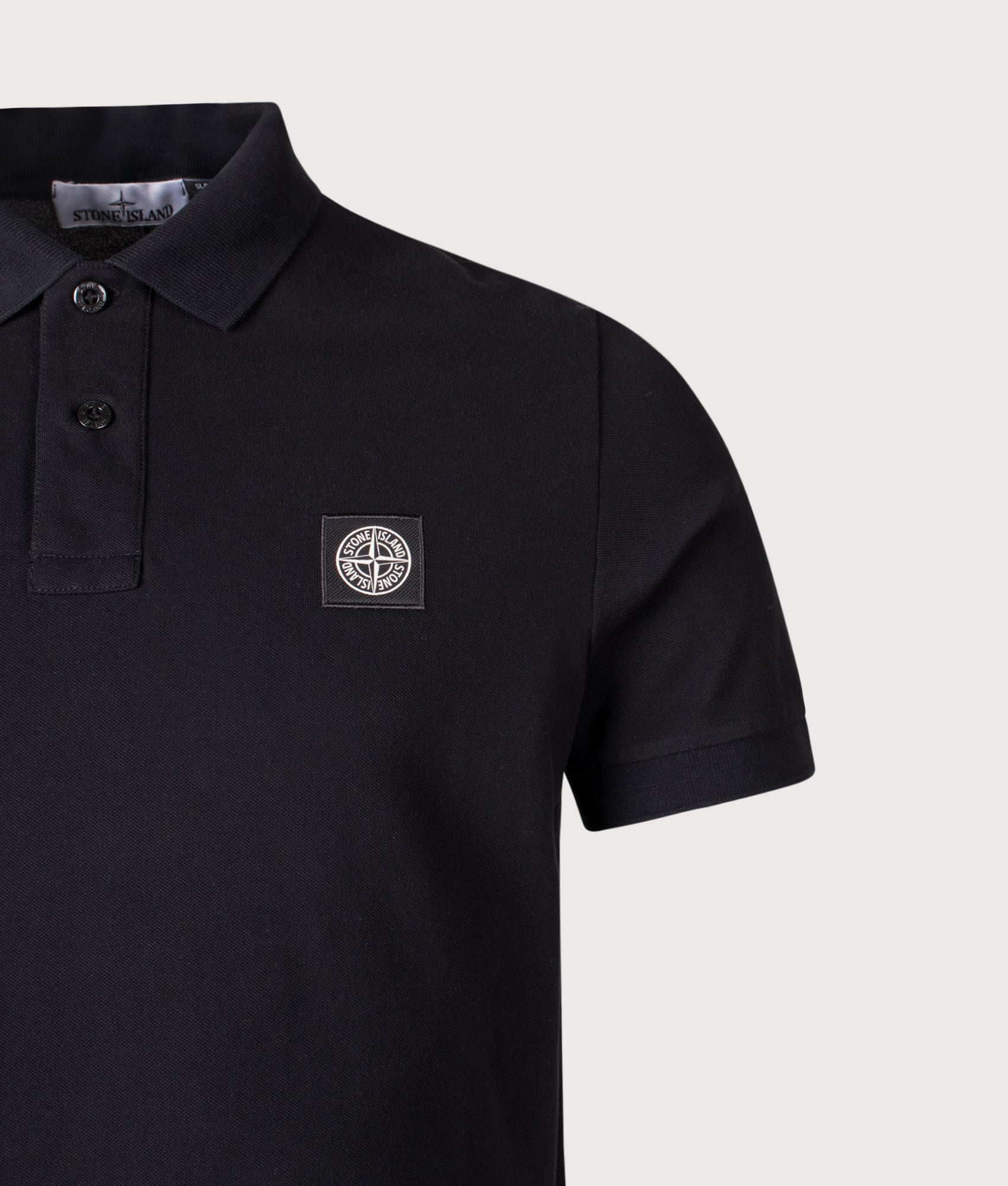 Stone Island Slim Fit Compass Patch Polo Shirt in Black at EQVVS Menswear. Detail shot.