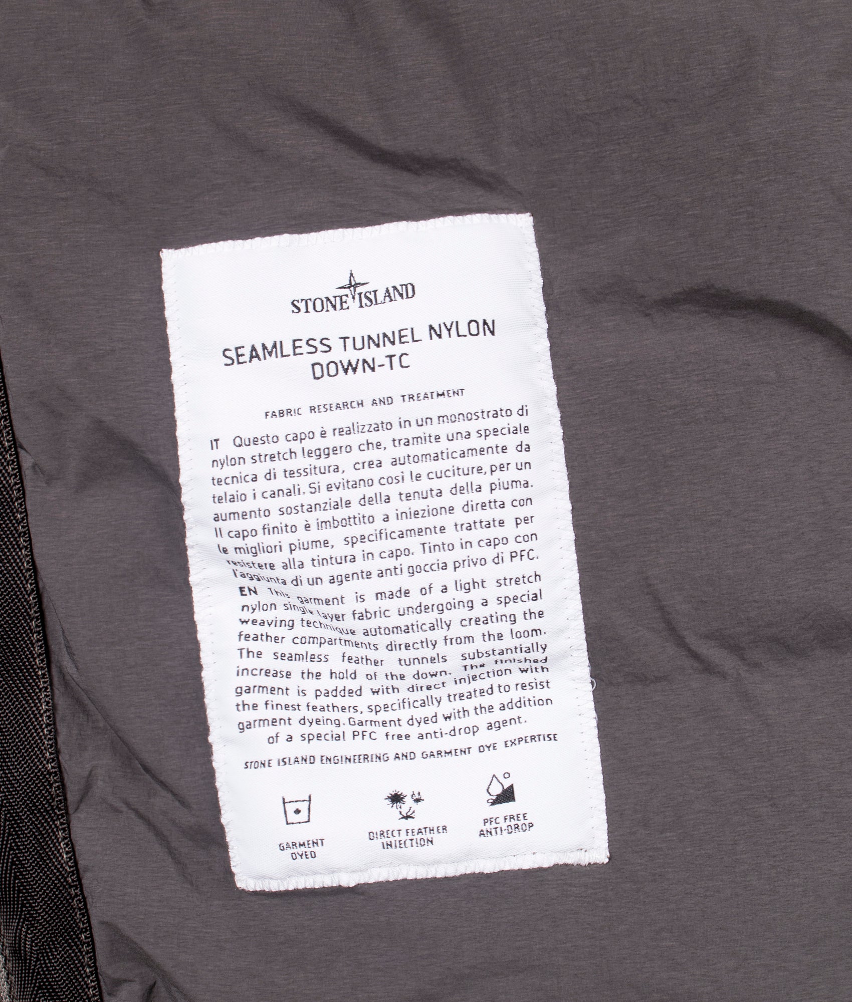 Stone Island Seamless Tunnel Nylon Down TC Jacket in Lead Grey at EQVVS Menswear. Label detail shot.