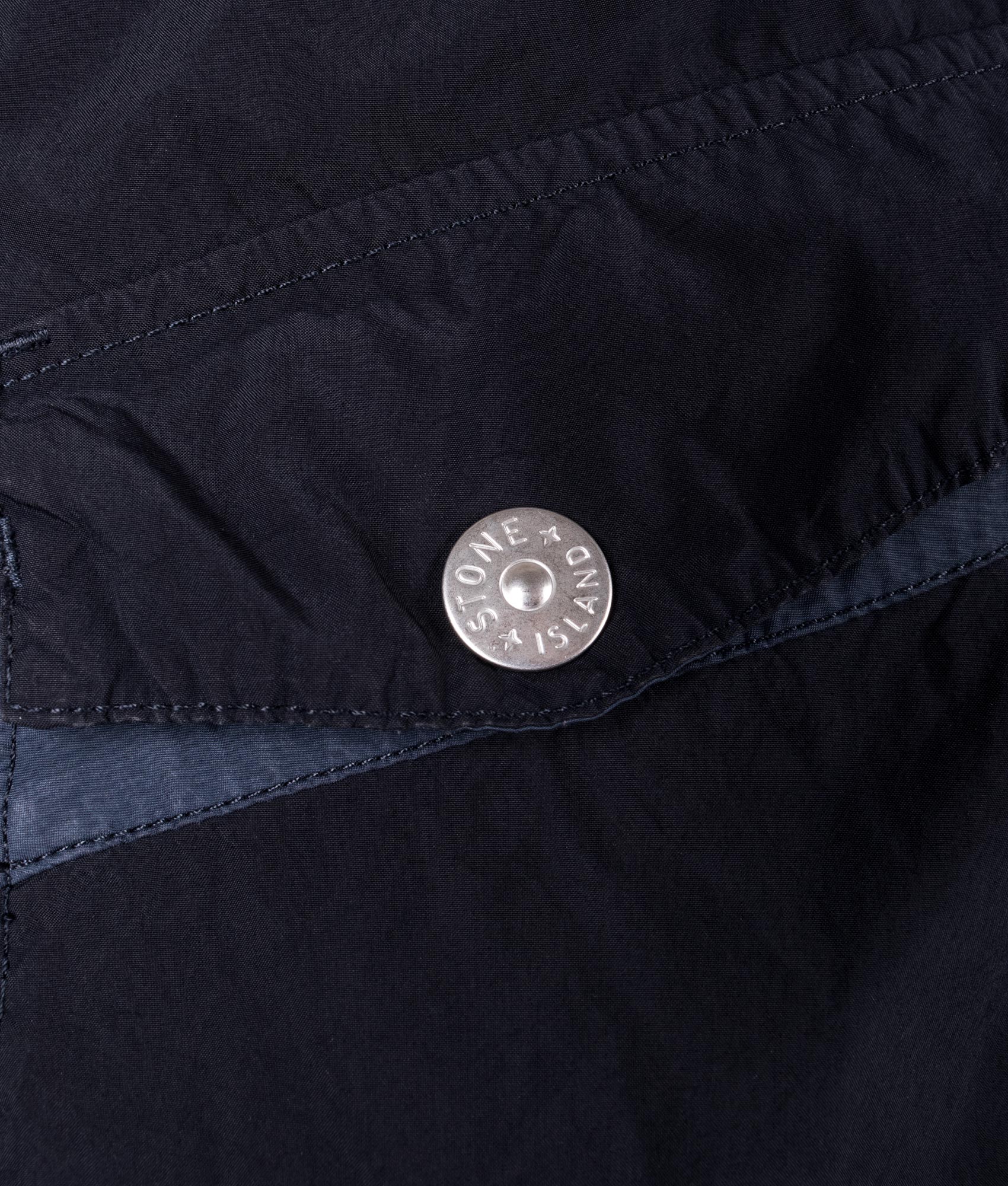 Light Compact Field Parka by Stone Island in Navy Blue. Shot by EQVVS. Detail button shot.