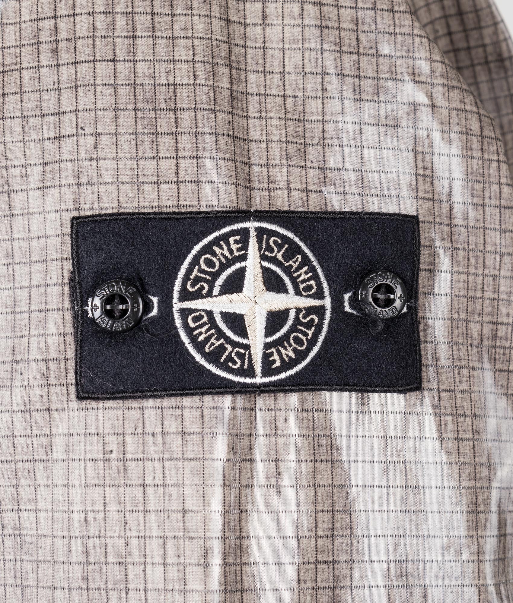 Uneven Ripstop Prismatico Parka in Pearl Grey | Stone Island | EQVVS | Badge shot 