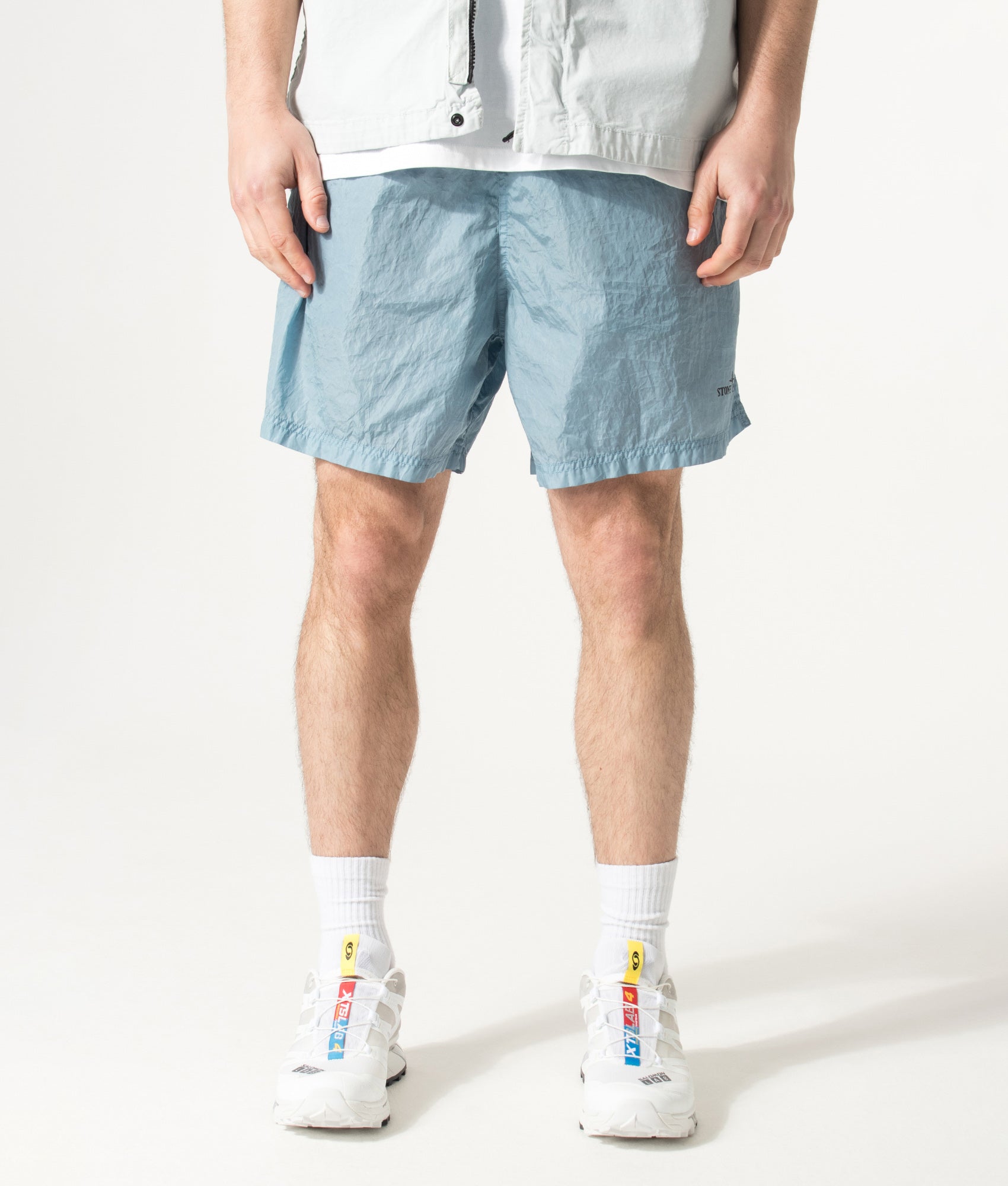 Stone Island Relaxed Fit Water Reactive Faded Camo Swim Shorts in Powder Blue at EQVVS Menswear. Model front shot.