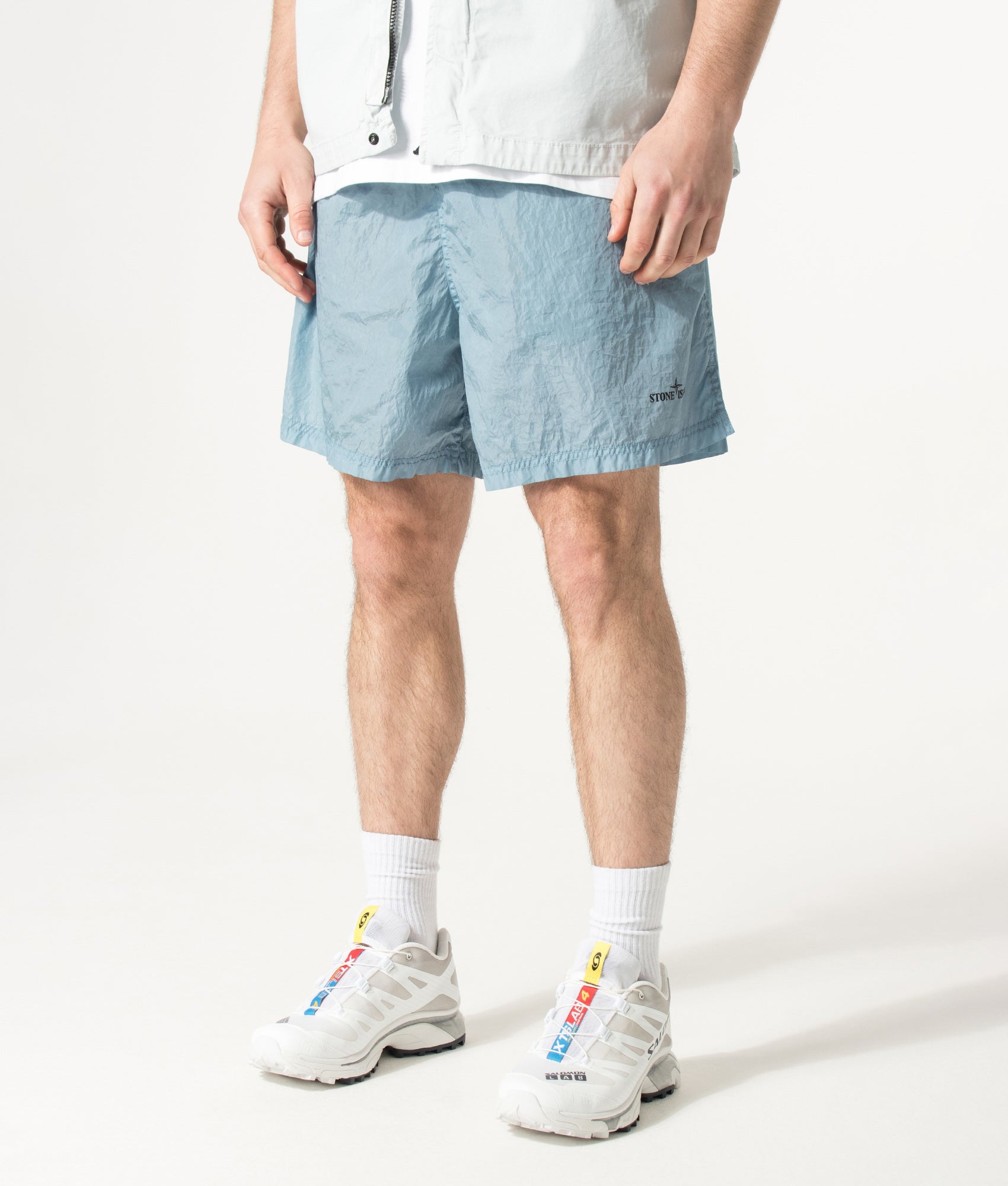 Stone Island Relaxed Fit Water Reactive Faded Camo Swim Shorts in Powder Blue at EQVVS Menswear. Angled model front shot.