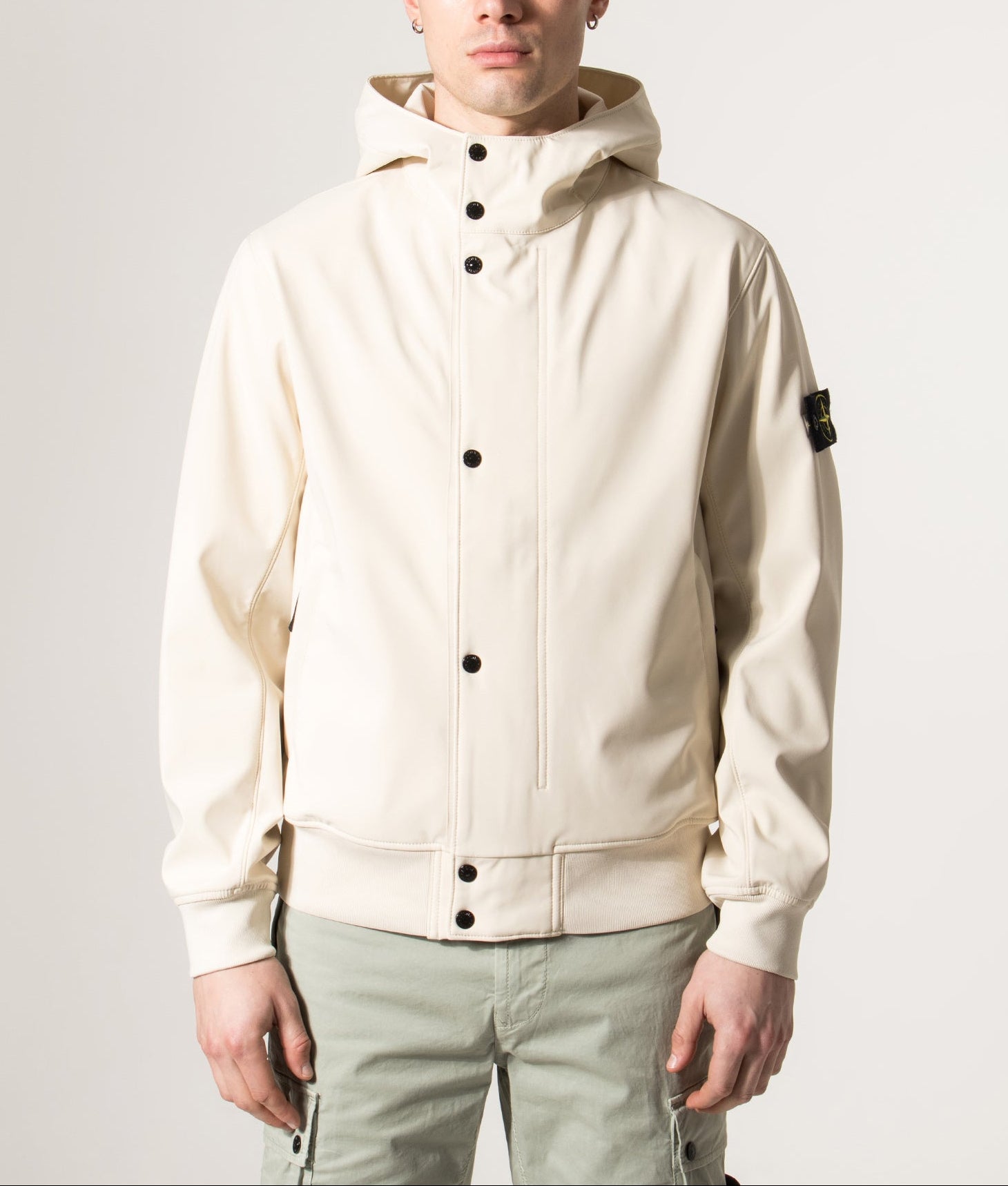 Stone Island Light Soft Shell-R E.DYE® Technology Hooded Jacket in Ivory at EQVVS Menswear. Model front shot.