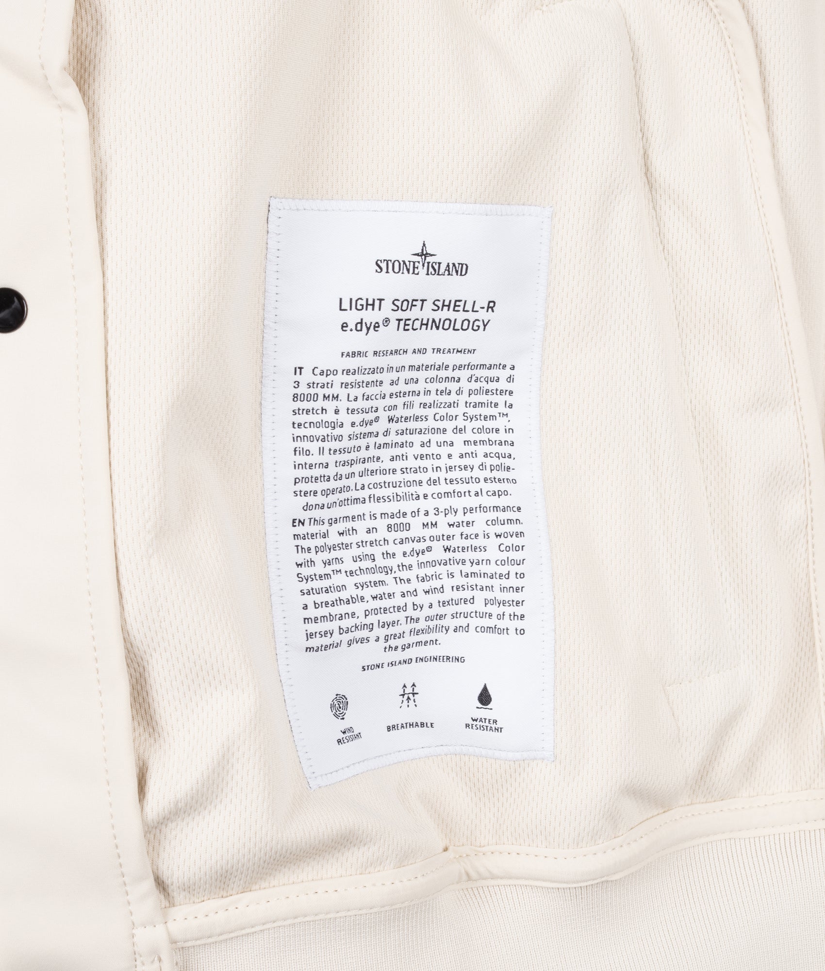 Stone Island Light Soft Shell-R E.DYE® Technology Hooded Jacket in Ivory at EQVVS Menswear. Label shot.