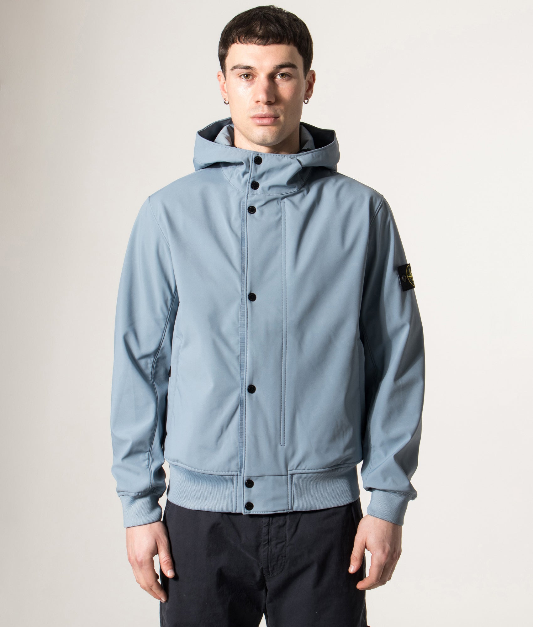Stone Island release the Light Soft Shell-R E.DYE® Technology Hooded Jacket in Avio Blue at EQVVS Menswear. Model front shot.