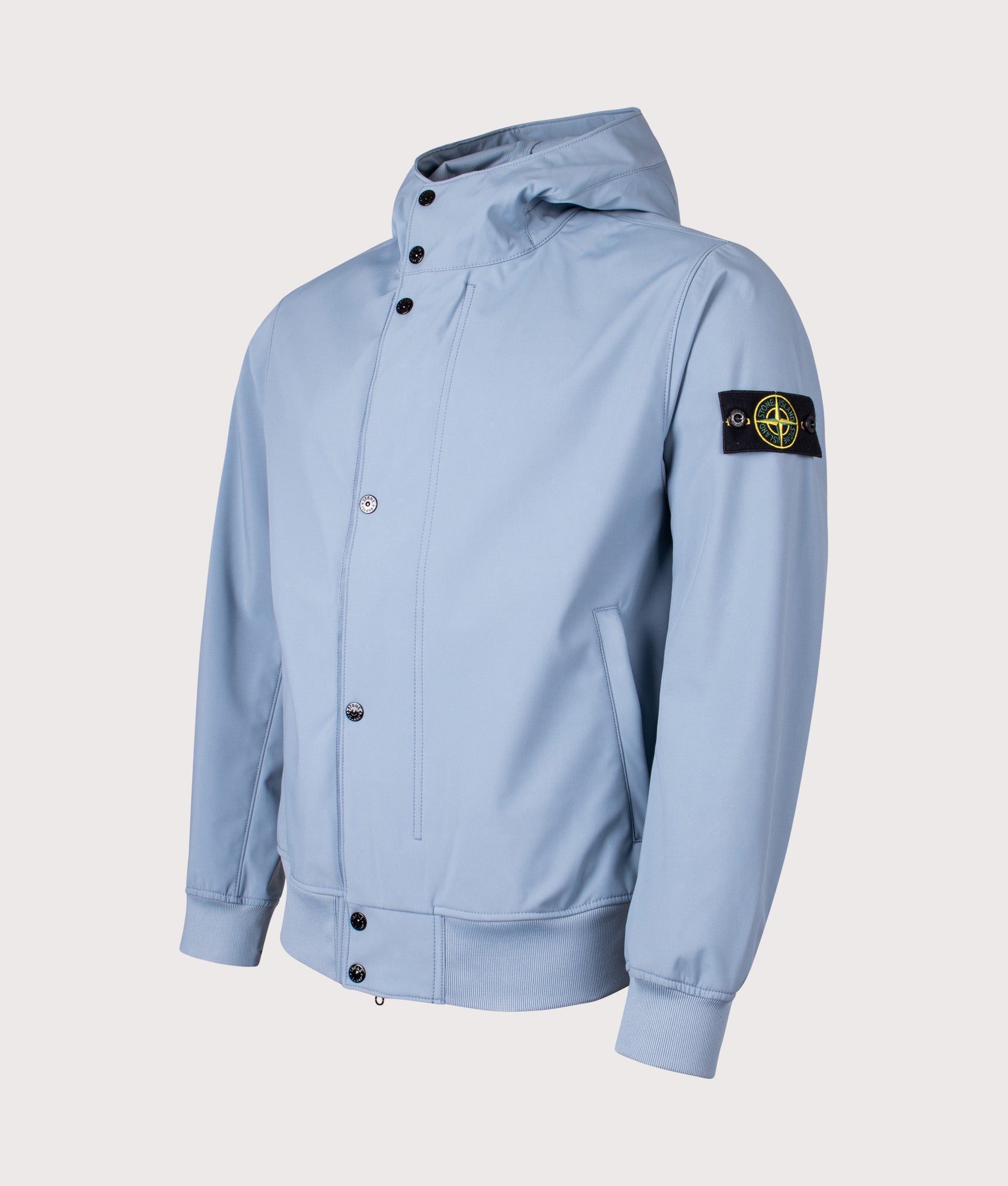 Stone Island release the Light Soft Shell-R E.DYE® Technology Hooded Jacket in Avio Blue at EQVVS Menswear. Angled front shot.