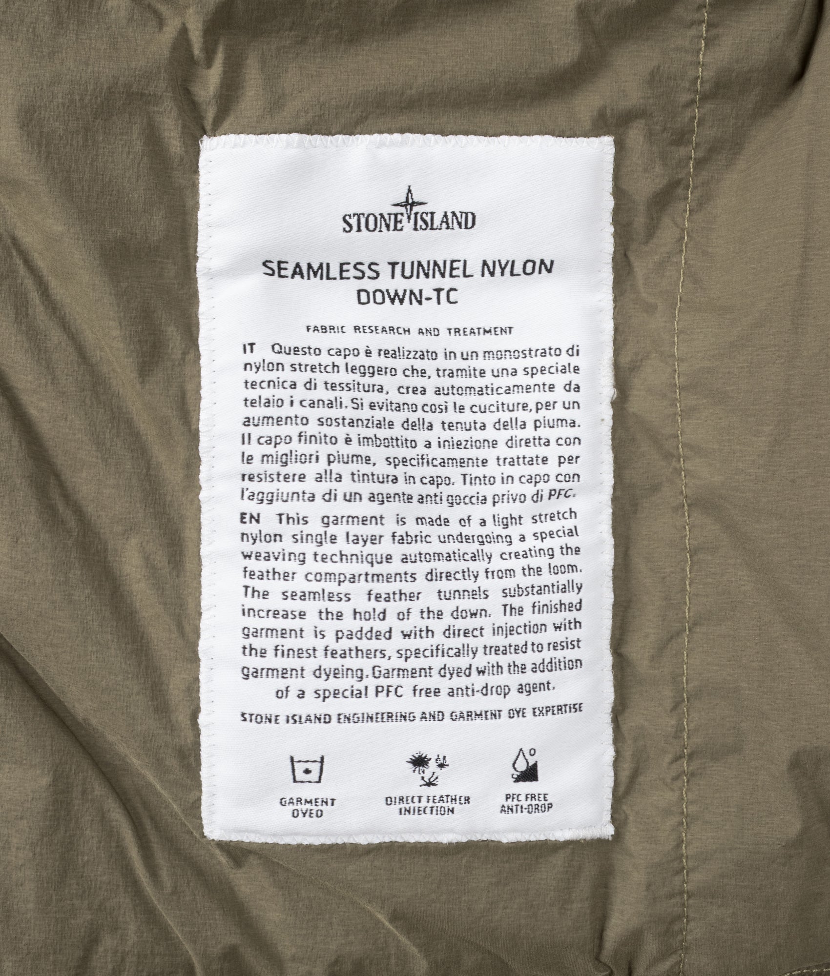 Stone Island Seamless Tunnel Nylon Down-TC Jacket in Military Green at EQVVS Menswear. Label shot.