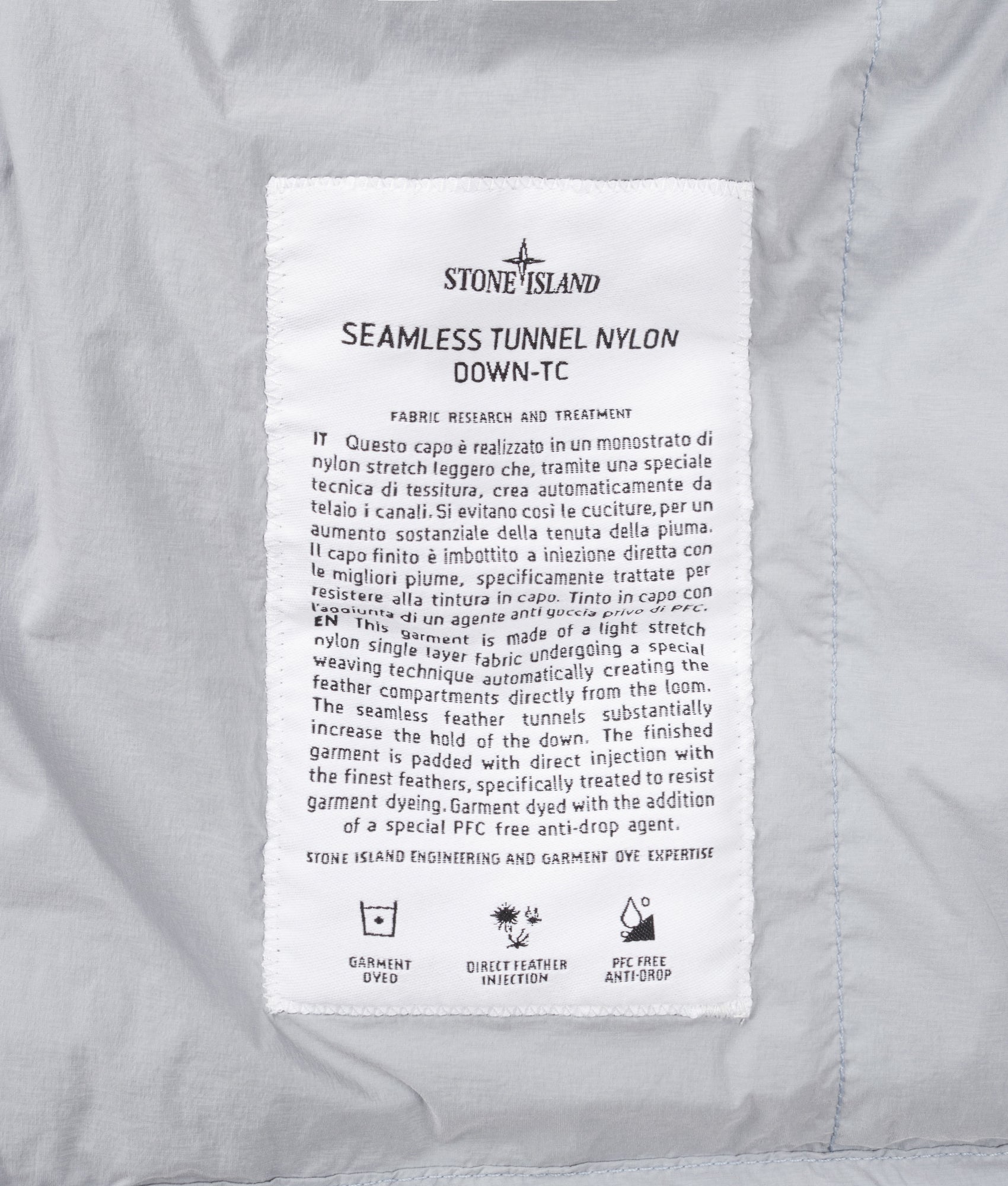 Stone Island Seamless Tunnel Nylon Down-TC Jacket in Ash Grey at EQVVS Menswear. Label shot.